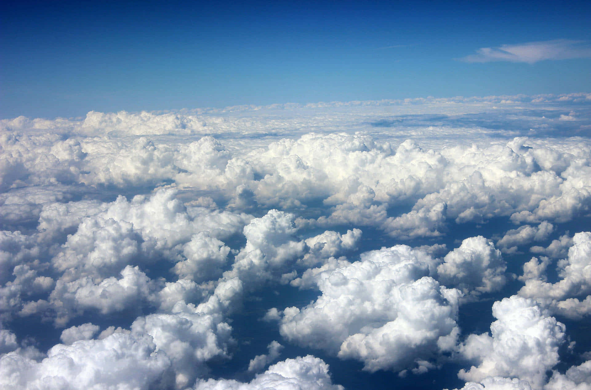 Aesthetic Cloud 桌布 壁紙 — 從高空俯瞰，蓬鬆的白雲在清澈的藍天下無盡延伸。