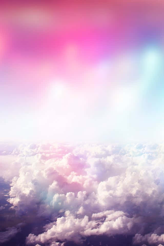 Heavenly 桌布 壁紙 — 從高空俯瞰，蓬鬆的雲朵沐浴在柔和的粉紅和藍色色調中，在發光的天空下，如夢似幻。