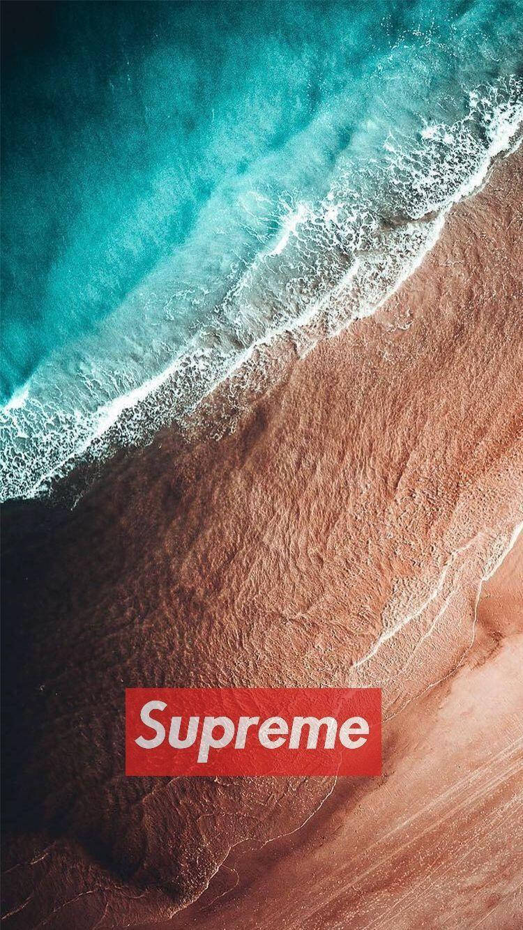 Dope Supreme 桌布 壁紙 — 從高空俯瞰，青綠色的海浪拍打著質感豐富的棕色沙灘，上面覆蓋著紅色的Supreme標誌。