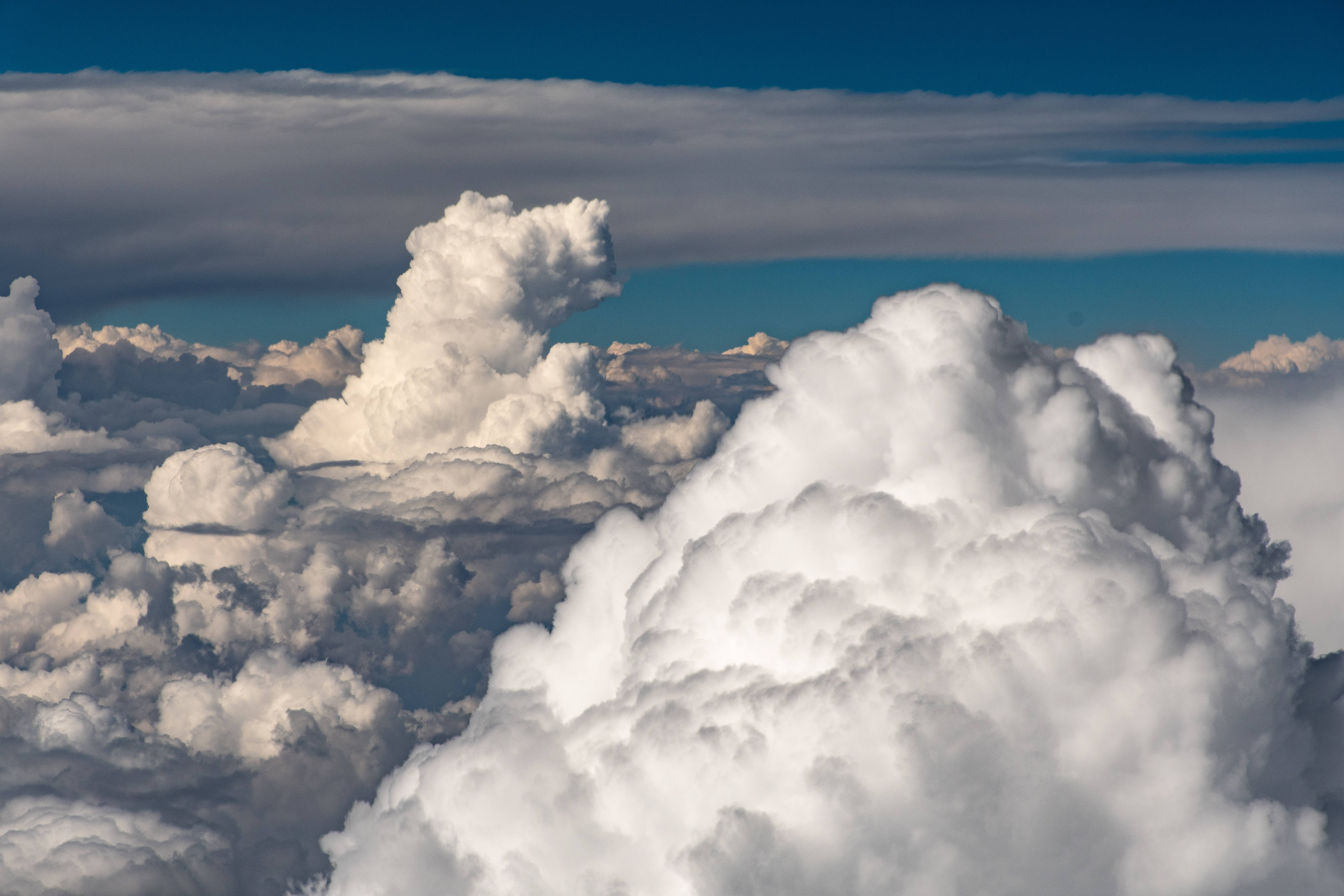 Clouds Aesthetics 桌布 壁紙 — 從高空俯瞰，高聳的白色積雲映襯著深藍色的天空，帶有柔和陰影。