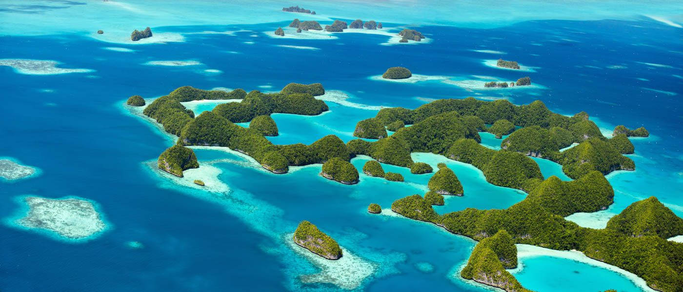 Micronesia 桌布 壁紙 — 從高空俯瞰，鬱鬱蔥蔥的綠色島嶼散落在充滿活力的藍綠色和深藍色海洋中。