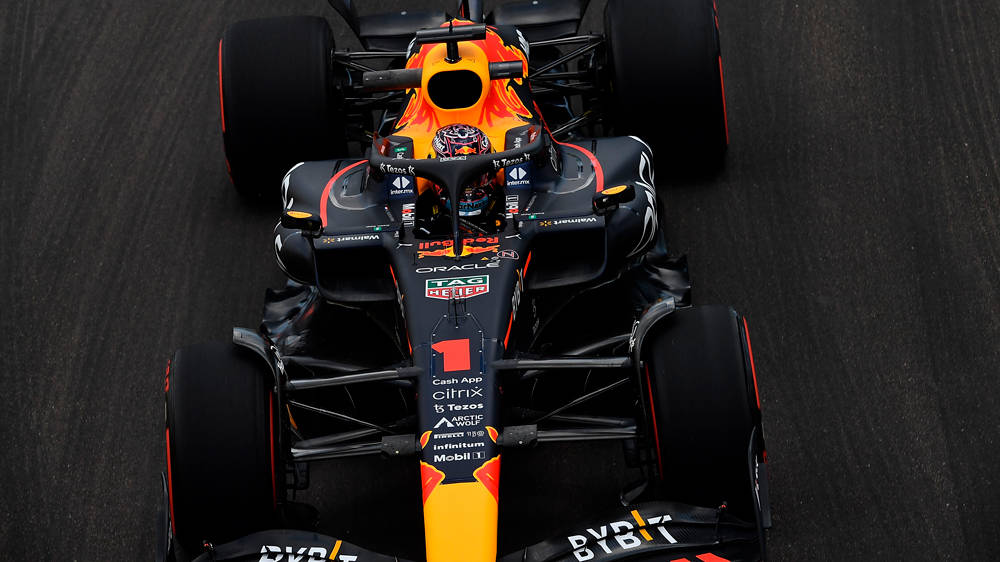 Red Bull 桌布 壁紙 — 從高空俯瞰一輛紅牛一級方程式賽車，車身編號一號，在深色瀝青賽道上疾馳。