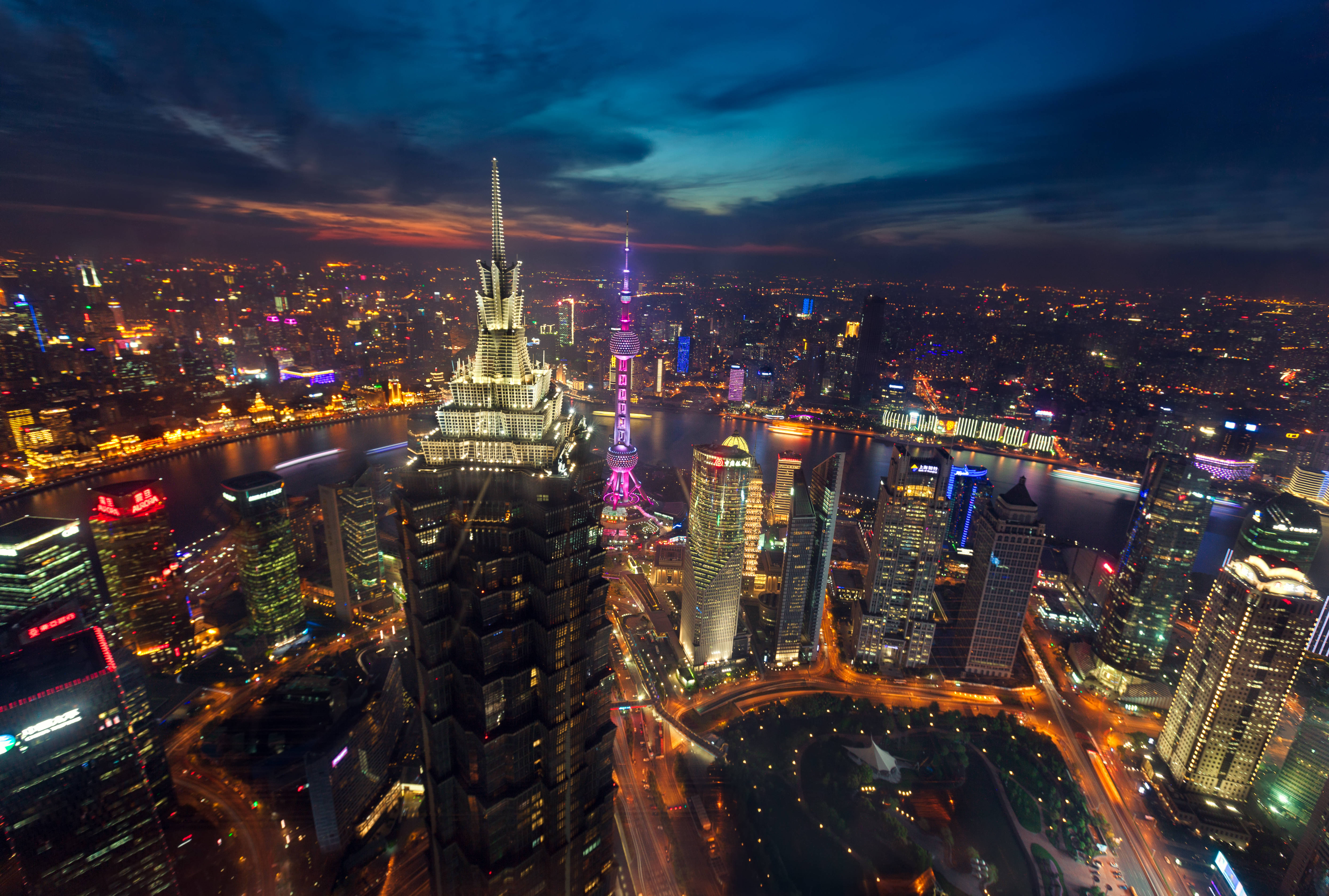 Shanghai 桌布 壁紙 — 從高空俯瞰上海黃昏時分璀璨的天際線，東方明珠塔和摩天大樓在暮色中閃耀。