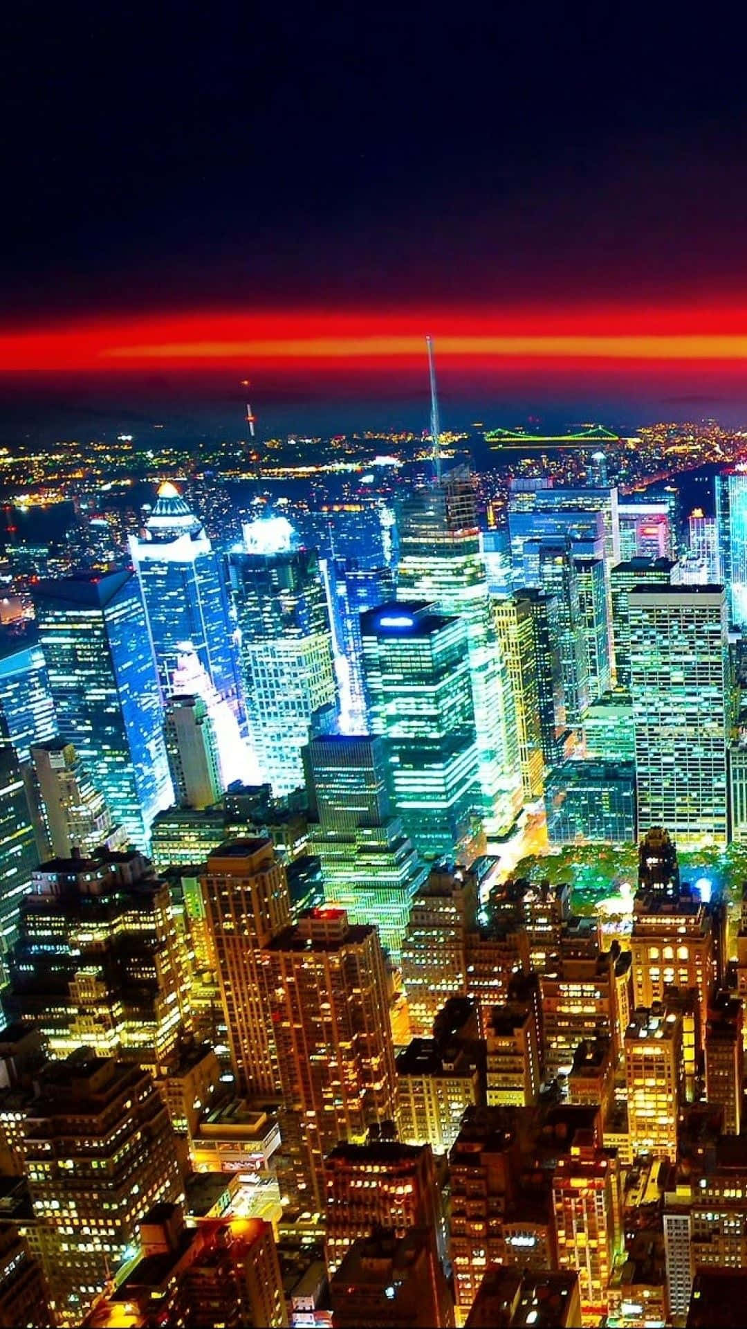 夜空 桌布 壁紙 — 從高空俯瞰充滿活力的夜景，閃爍的摩天大樓上方是火紅的天空。