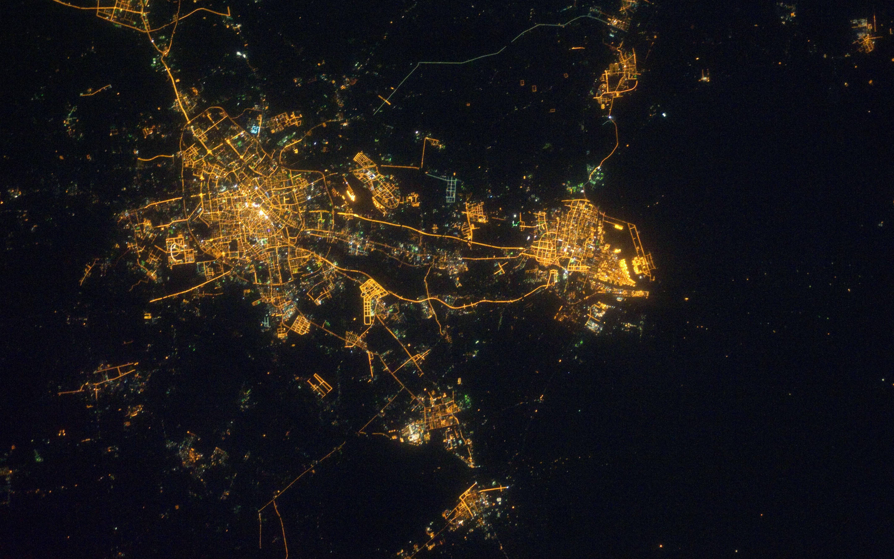 Tianjin 桌布 壁紙 — 從高空俯瞰夜晚的城市，金色路燈和建築燈光在黑暗的天空下照亮了廣闊的城市。