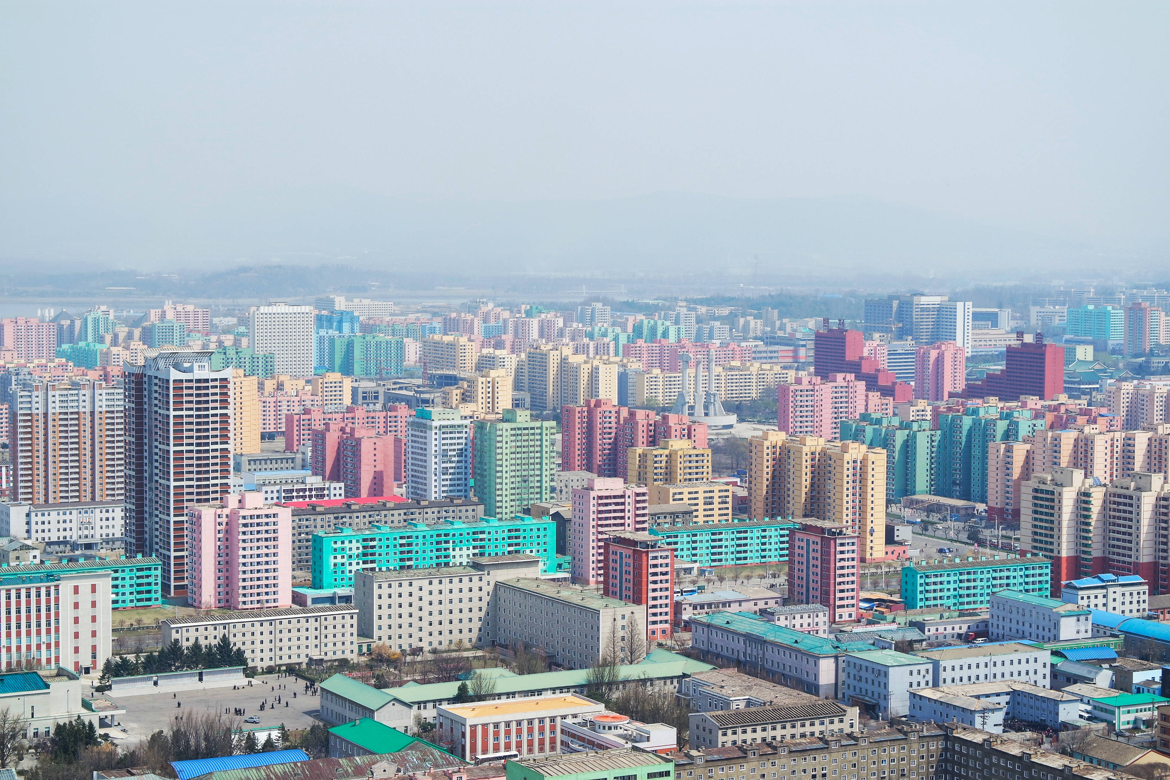 韓國 桌布 壁紙 — 從高空俯瞰廣闊的城市景觀，色彩繽紛的公寓樓群在朦朧的天空下。