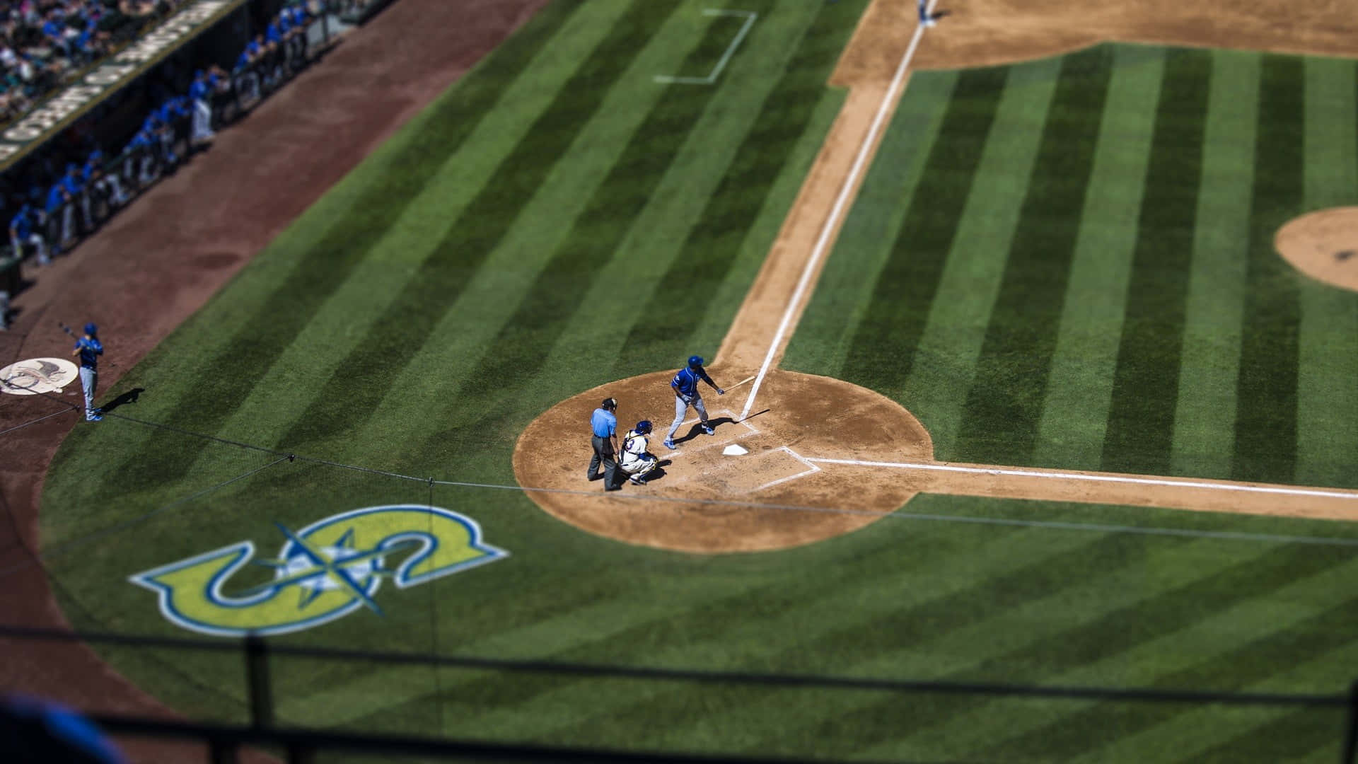 Baseball Field 桌布 壁紙 — 從高空俯瞰棒球比賽，球員在本壘板上，在陽光普照下，精心修剪的綠色球場上。
