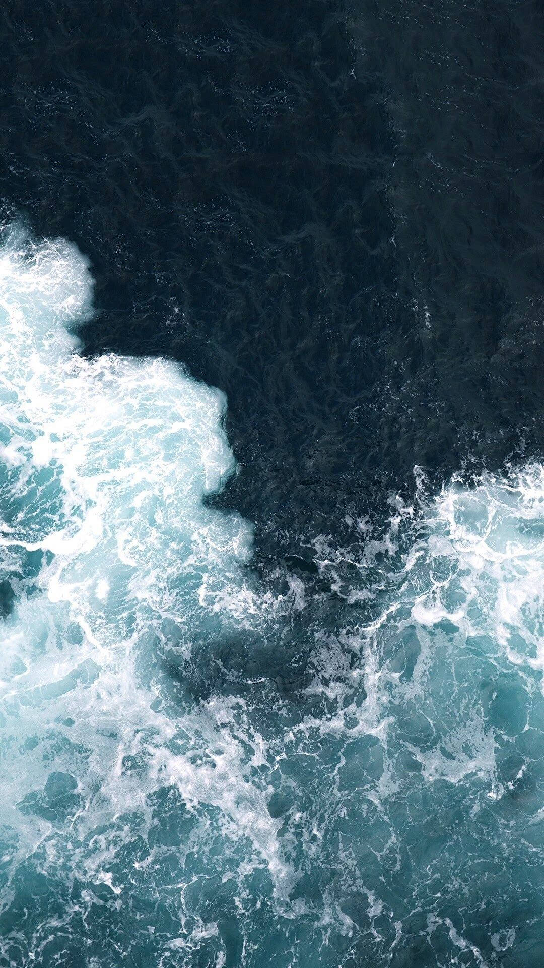 iPhone 桌布 壁紙 — 從高空俯瞰波濤洶湧的海浪，帶著白色泡沫拍打深藍綠色海水。