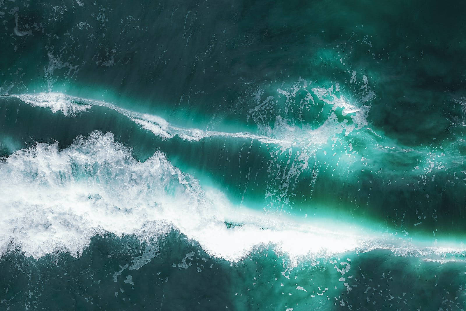 海洋 桌布 壁紙 — 從高空俯瞰波濤洶湧的海浪，白色泡沫撞擊深藍綠色海水。