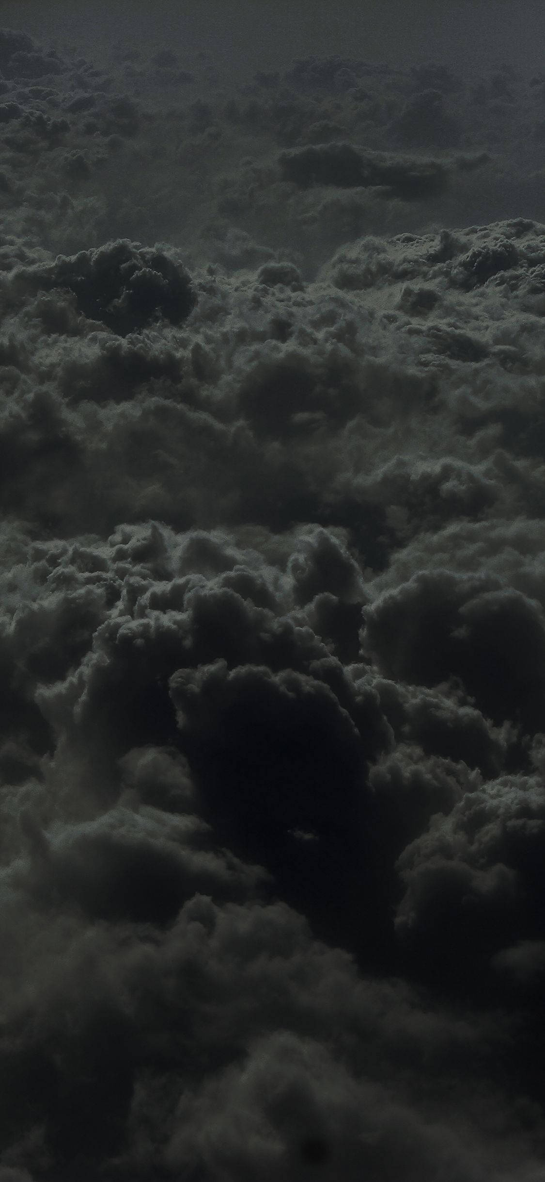 雲朵 桌布 壁紙 — 從高空俯瞰濃密烏雲在陰沉大氣天空中翻騰的景象。