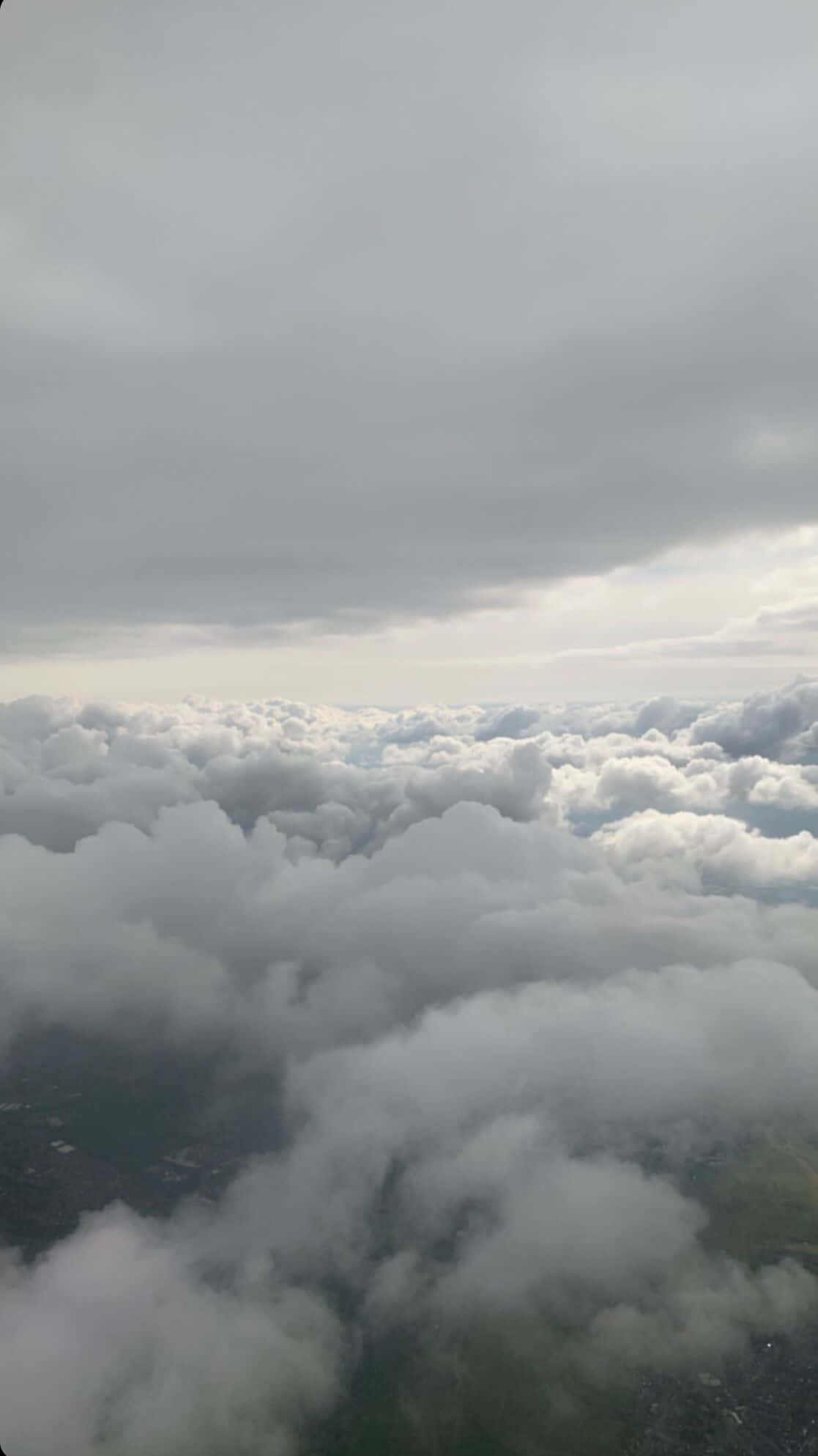 Instagram 桌布 壁紙 — 從高空俯瞰無盡棉花般的雲層，陰天之下隱約可見下方的綠色大地。