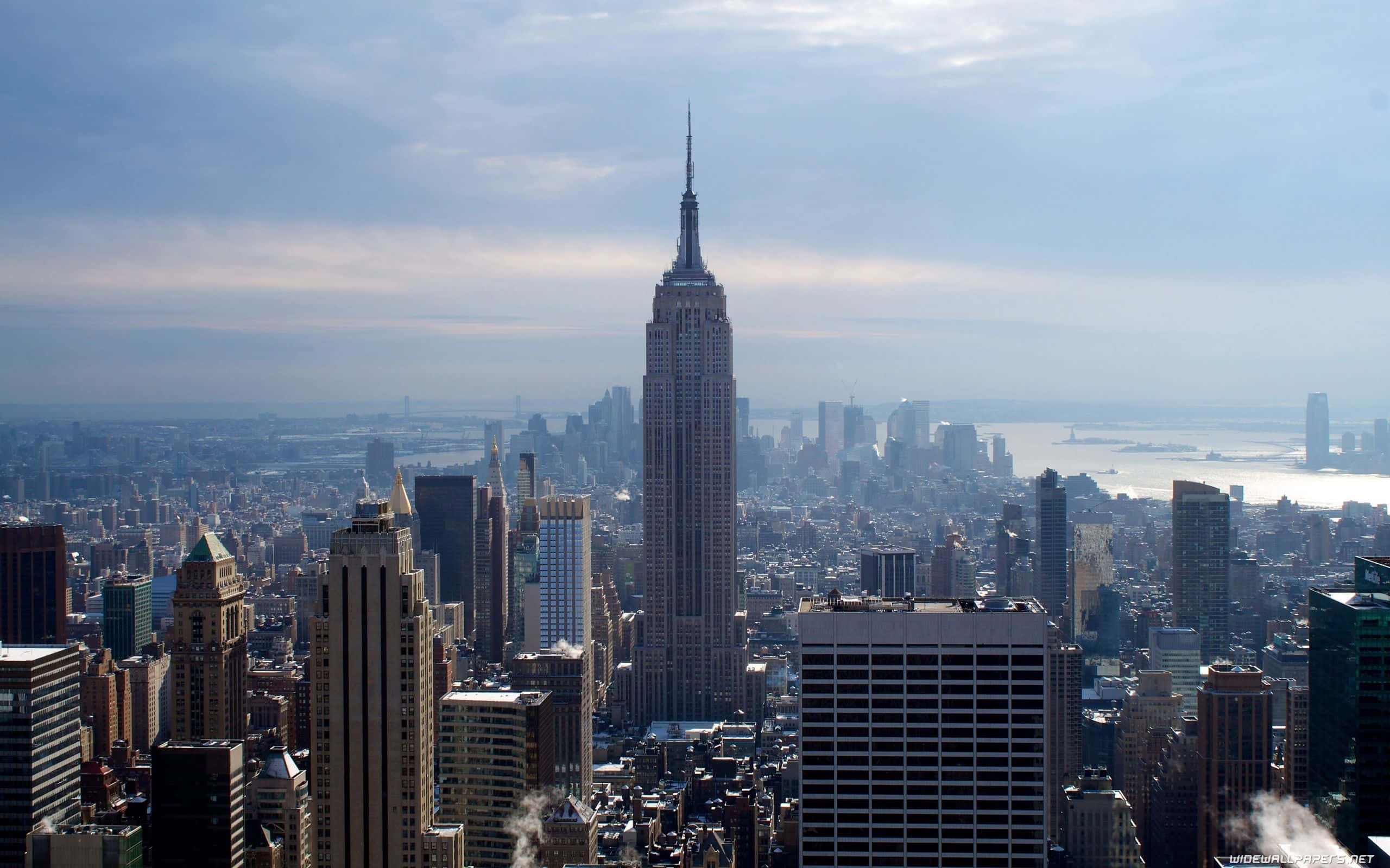 New York City 4K Ultra HD 桌布 壁紙 — 從高空俯瞰紐約市天際線，帝國大廈在朦朧藍天下佔據主導地位。