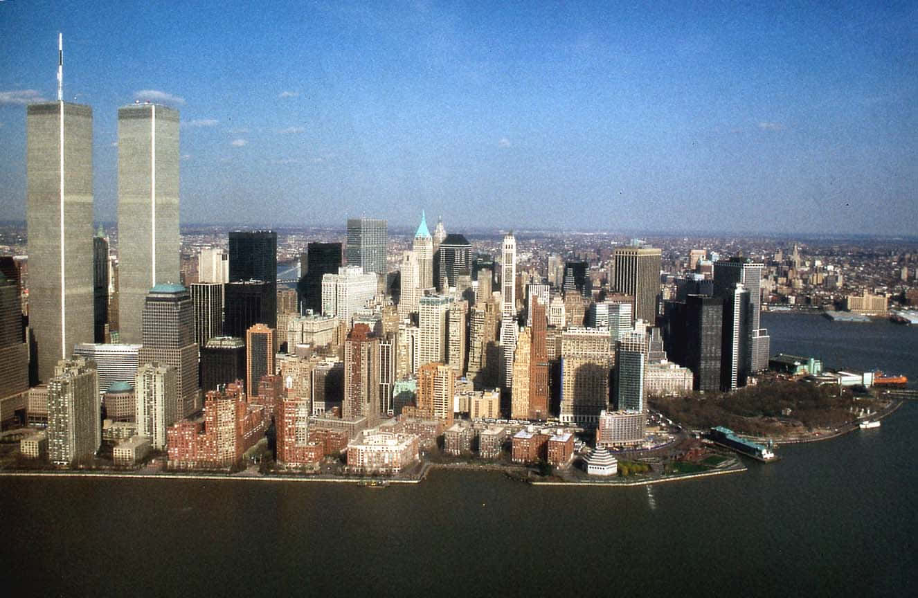 New York 桌布 壁紙 — 從高空俯瞰紐約市天際線，雙子星大樓在清澈藍天下佔據主導地位，哈德遜河在前景。