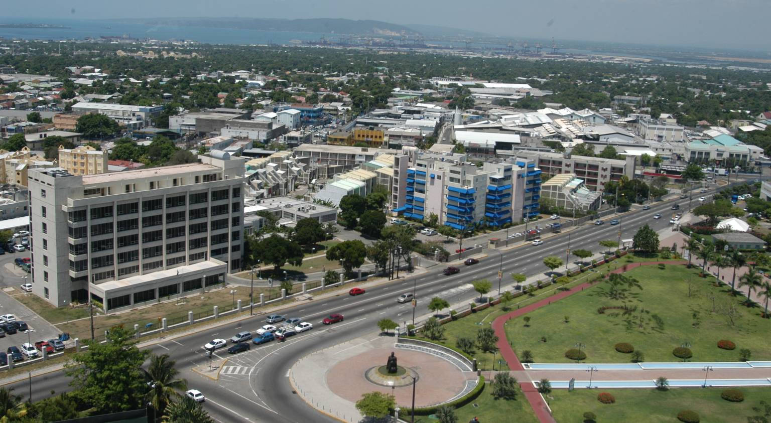 Jamaica 桌布 壁紙 — 從高空俯瞰繁華的城市景觀，寬闊的道路、汽車、建築物和綠色公園，天空朦朧。
