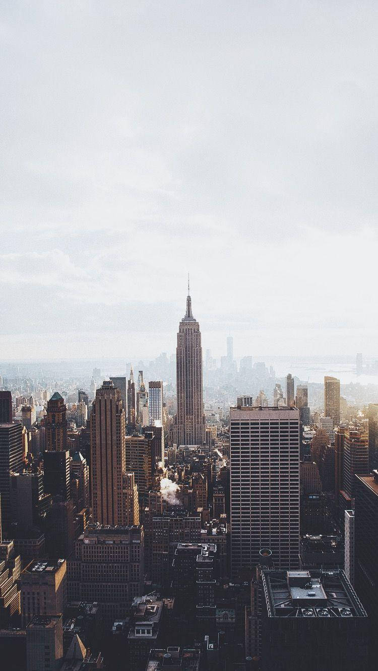 New York 桌布 壁紙 — 從高角度俯瞰紐約市天際線，帝國大廈在陰霾密佈的天空下佔據主導地位。