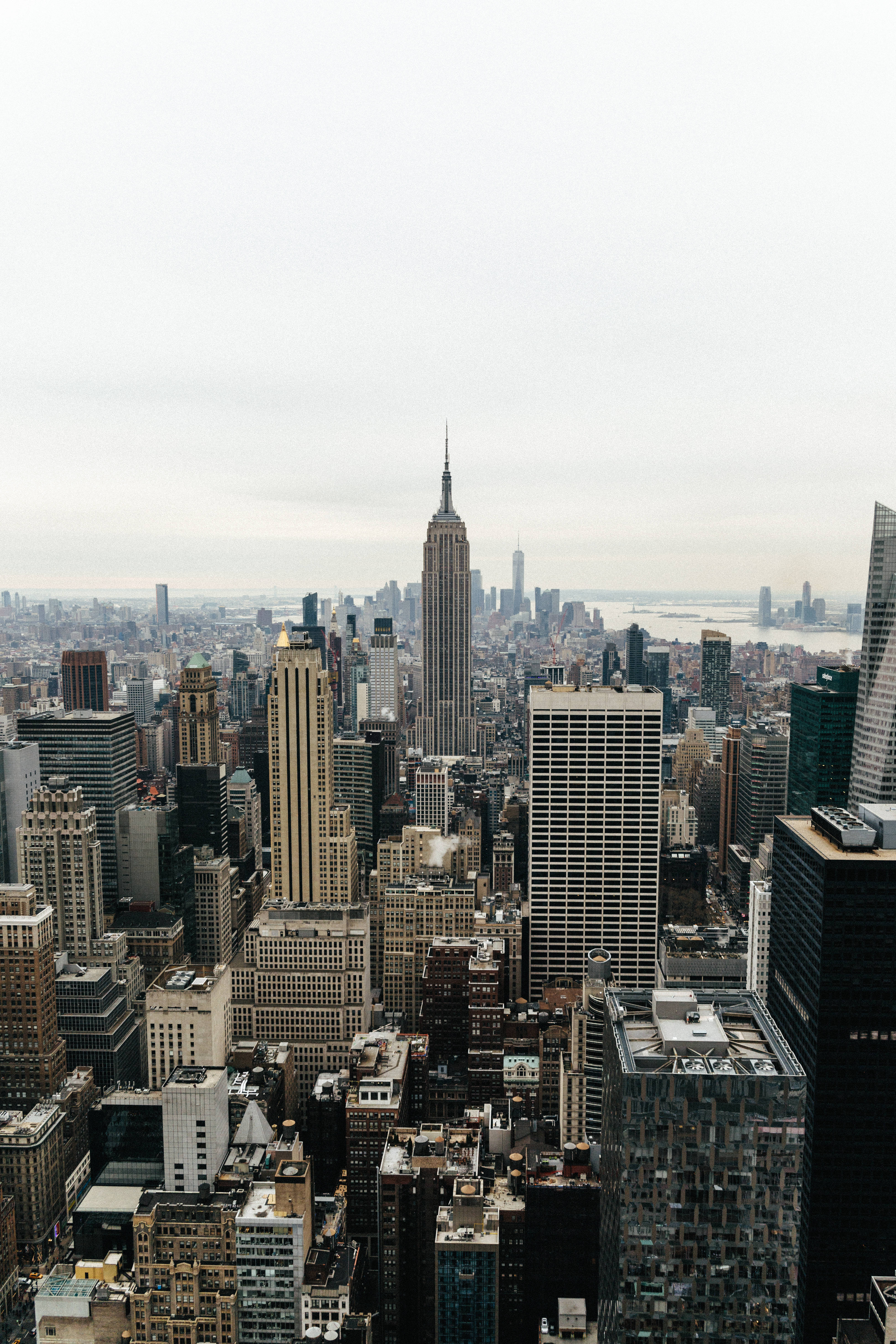 empire state 桌布 壁紙 — 從高角度俯瞰紐約市天際線，帝國大廈在陰天中佔據主導地位。