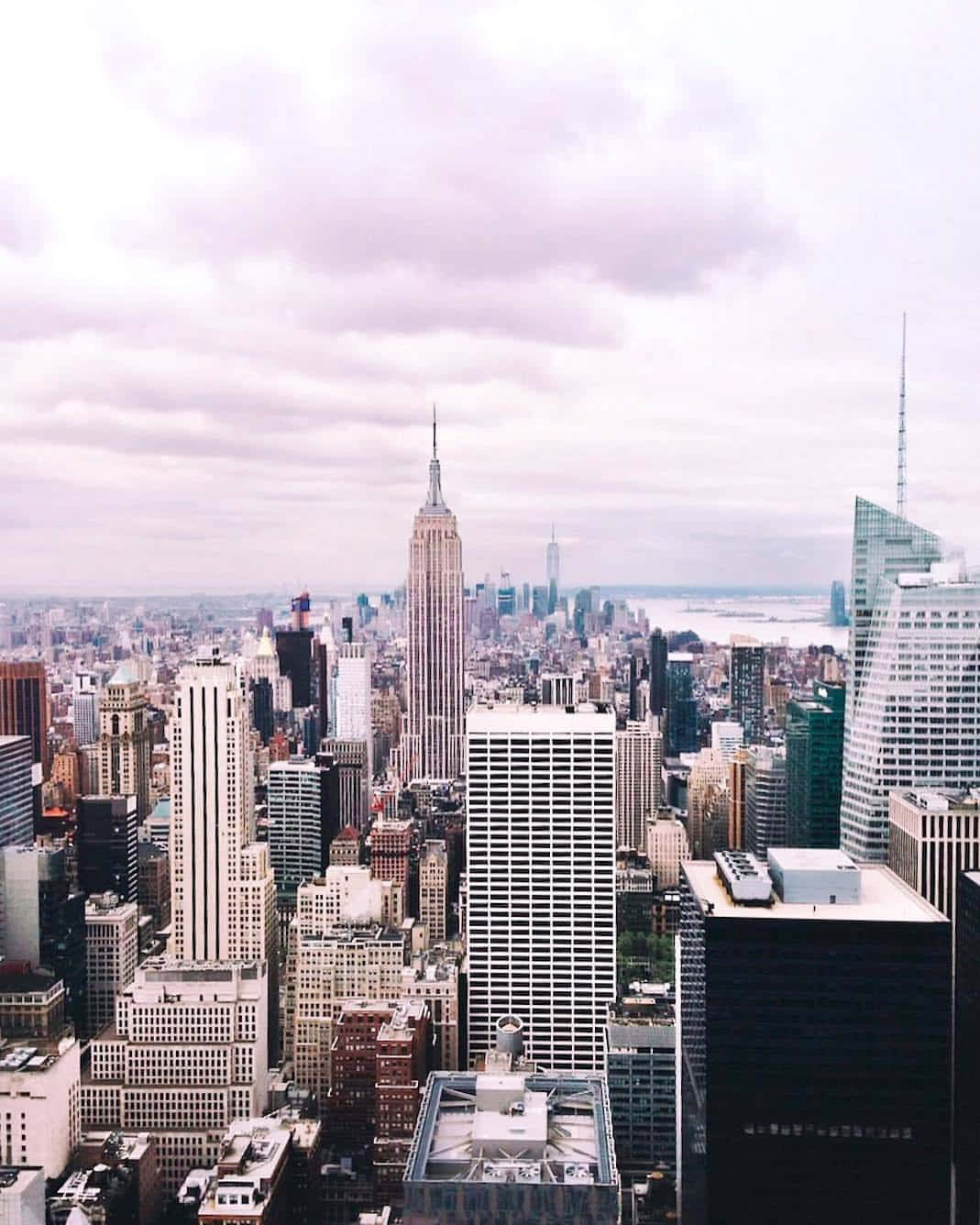 New York 桌布 壁紙 — 從高角度俯瞰紐約市天際線，柔和陰天，帝國大廈聳立於周圍摩天大樓之上。