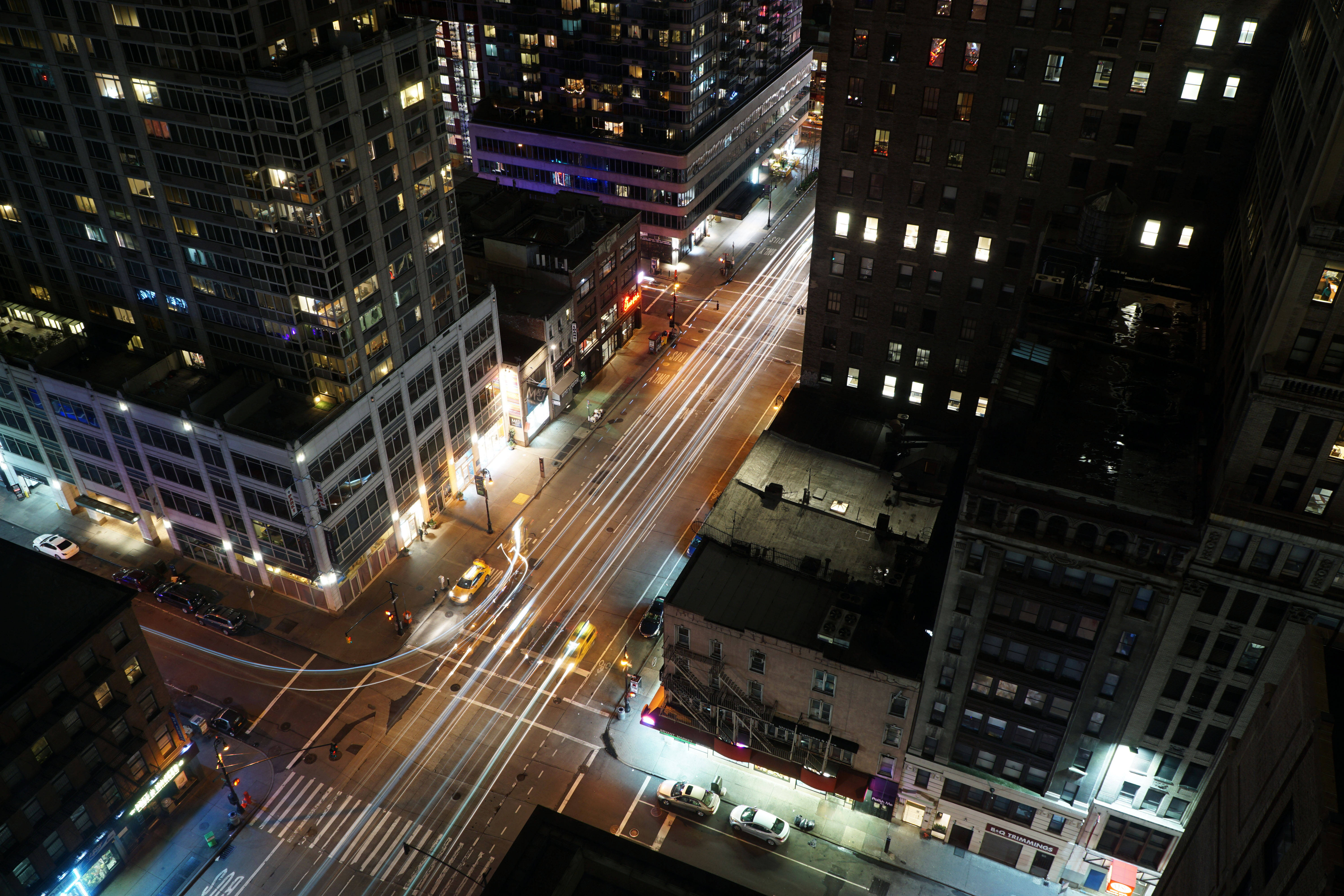 Screensavers 桌布 壁紙 — 從高角度拍攝的繁華城市街道夜景，帶有發光的窗戶和行駛汽車的光跡。
