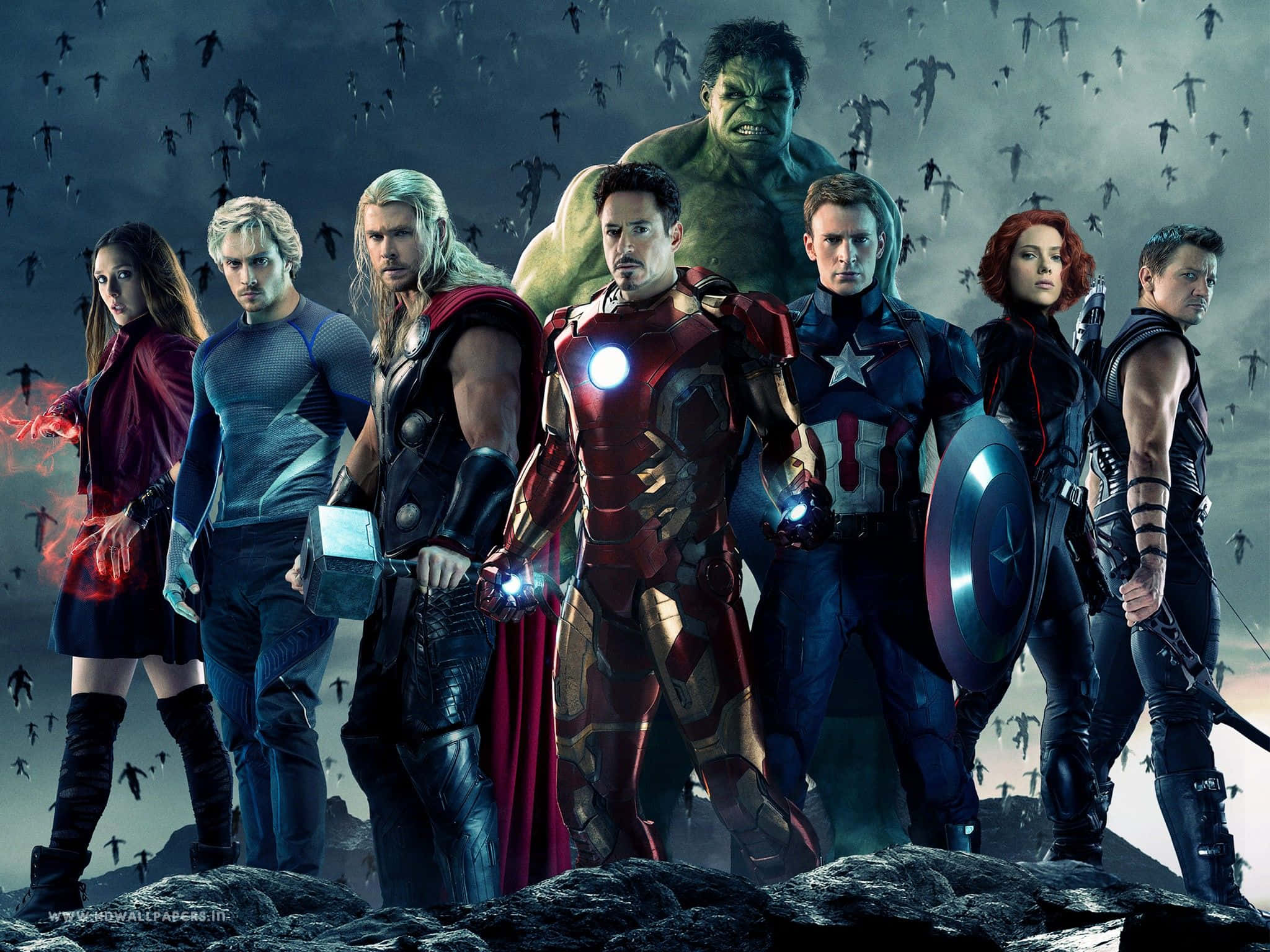 Avengers Movie 桌布 壁紙 — 復仇者聯盟聚集在岩石懸崖上，陰影人物在上方蜂擁，呈現戲劇性的電影姿勢。