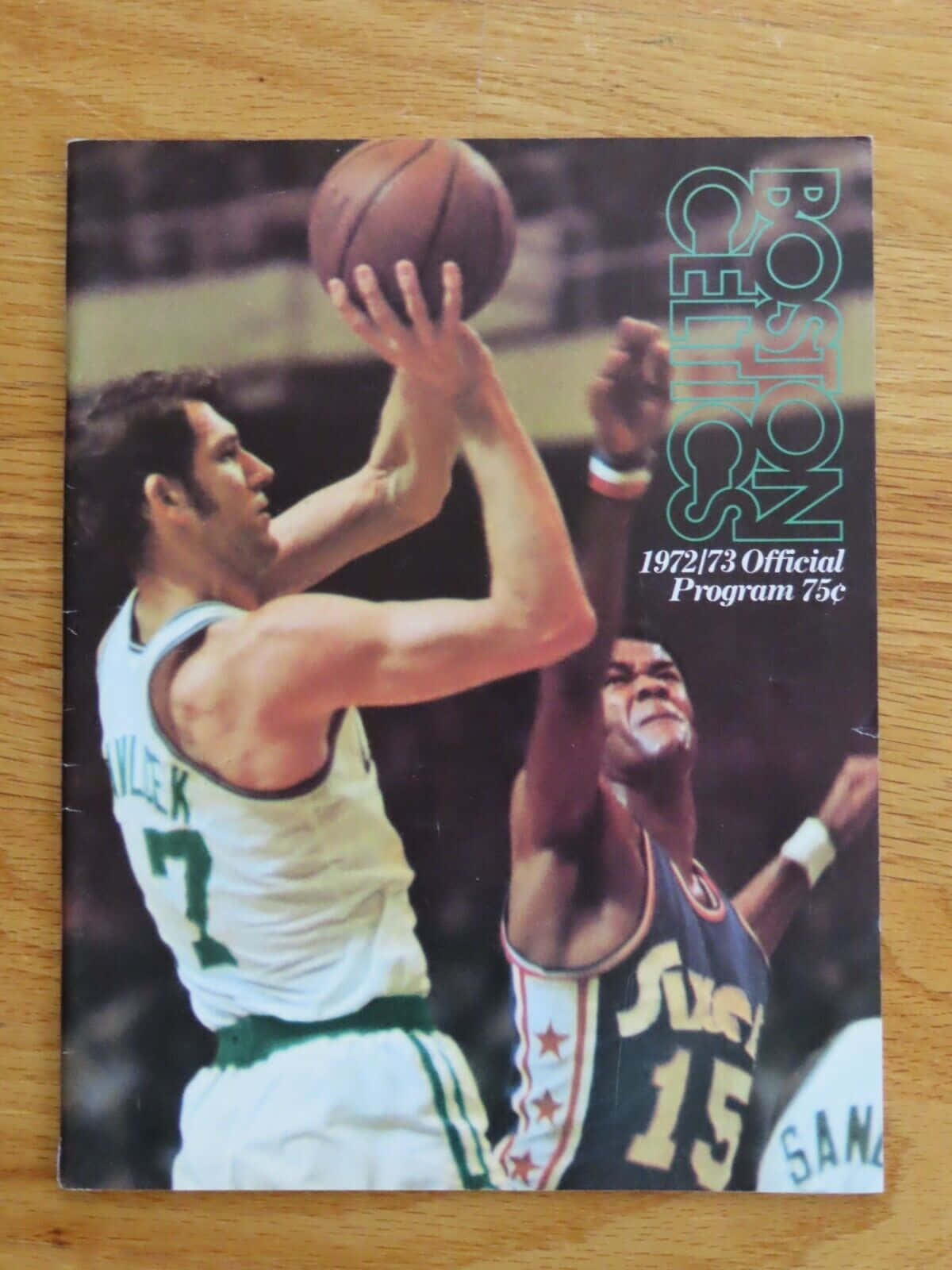 籃球 桌布 壁紙 — 復古197273年波士頓塞爾提克節目封面顯示球員7號在防守者15號上方投籃，激烈的籃球動作。