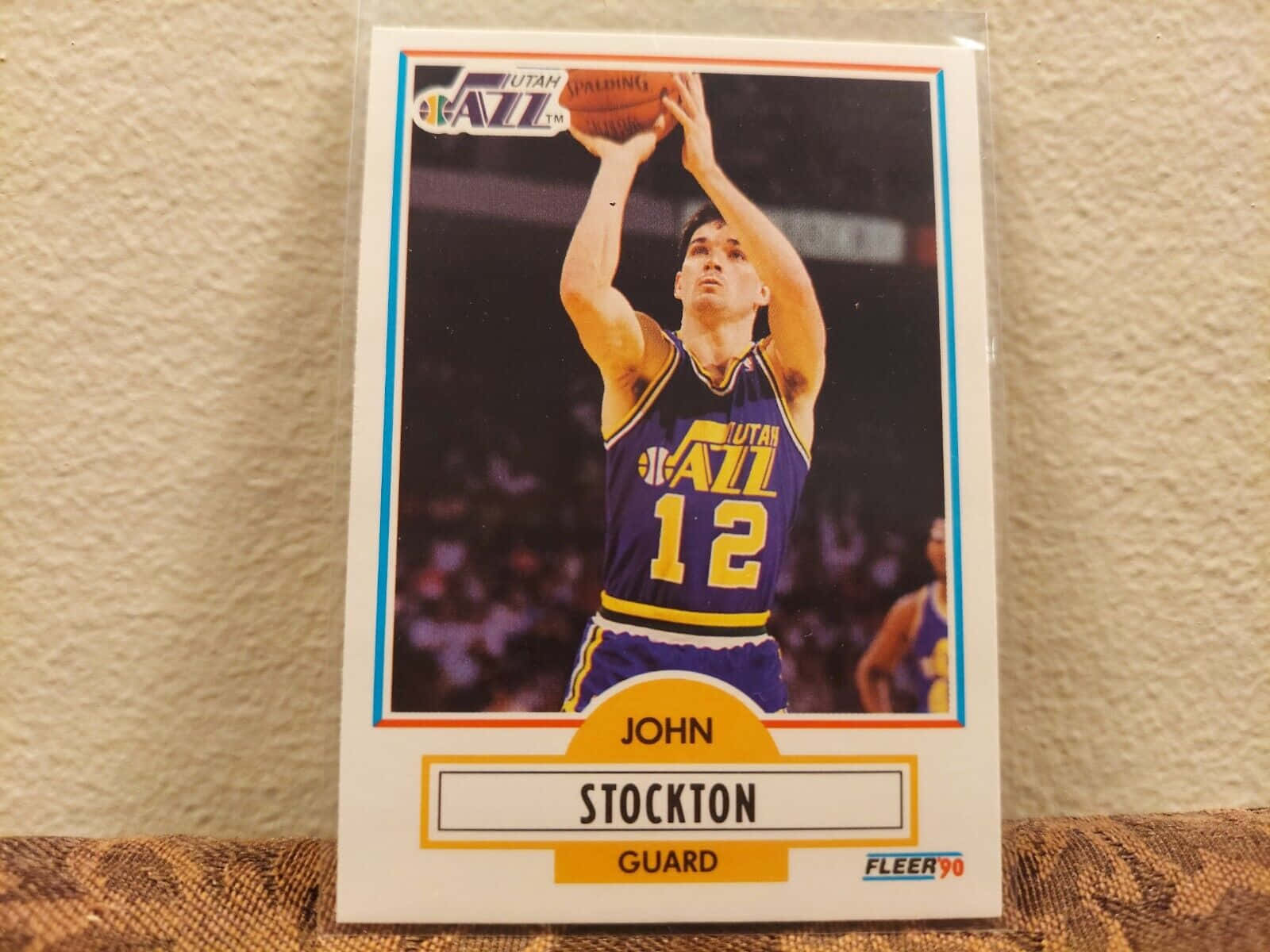 NBA 桌布 壁紙 — 復古1990年Fleer籃球卡，約翰·斯托克頓身穿紫色爵士隊球衣，在模糊的場館人群中投籃。