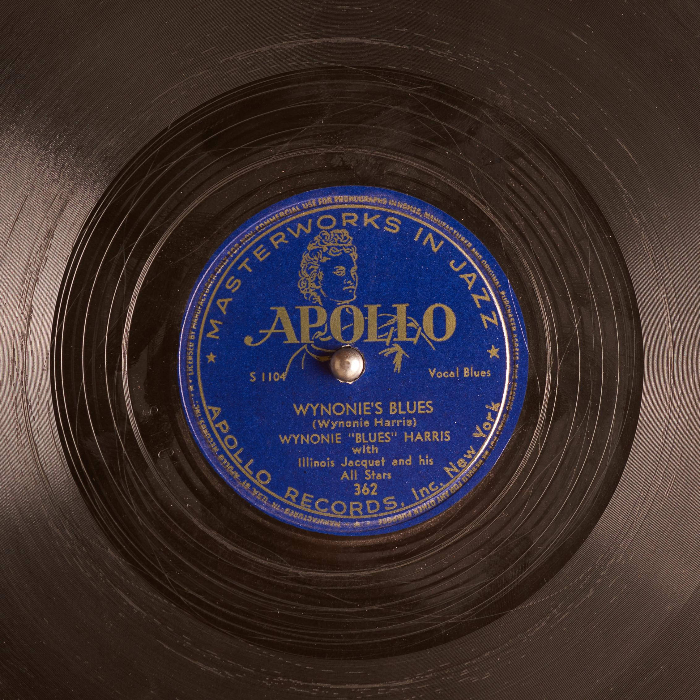 vinyl 桌布 壁紙 — 復古Apollo Records黑膠唱片標籤的特寫，藍色中心，金色文字，位於磨損的黑色唱片表面。