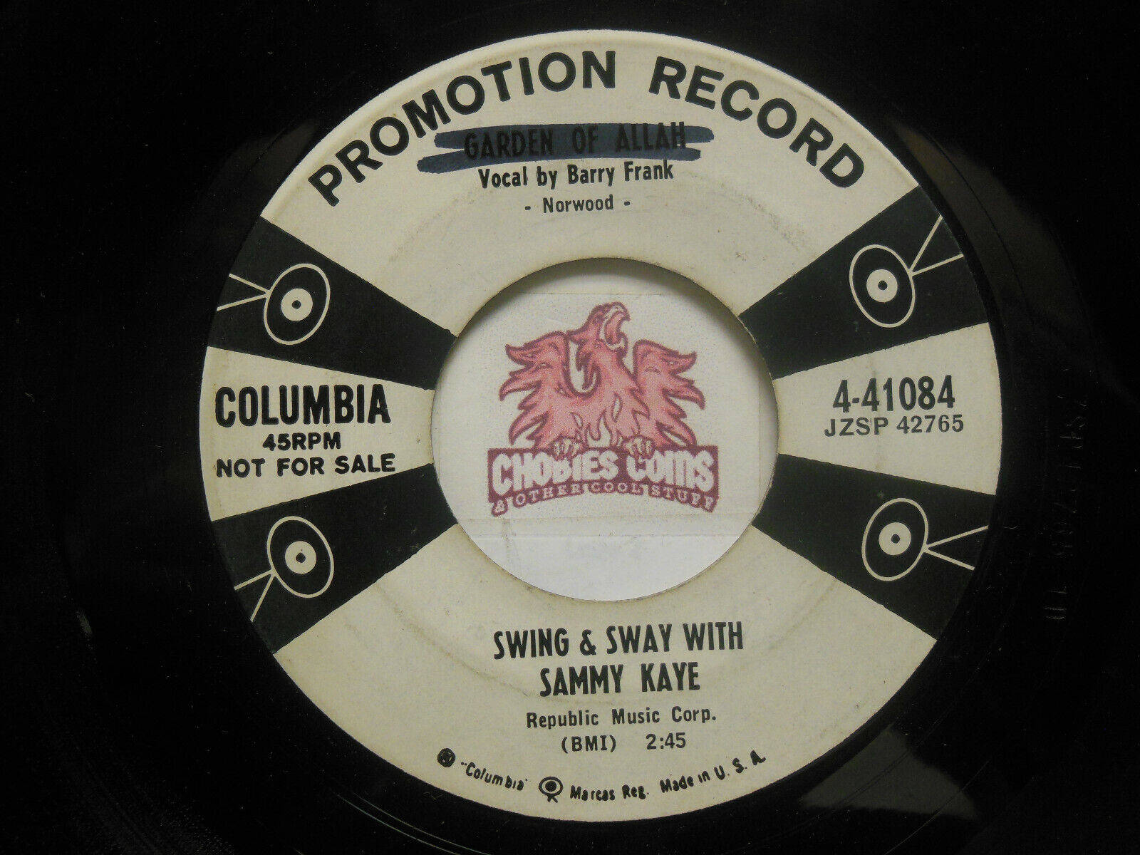 vinyl 桌布 壁紙 — 復古Columbia 45rpm宣傳唱片標籤特寫，帶有粉紅色龍標誌和黑白幾何設計。
