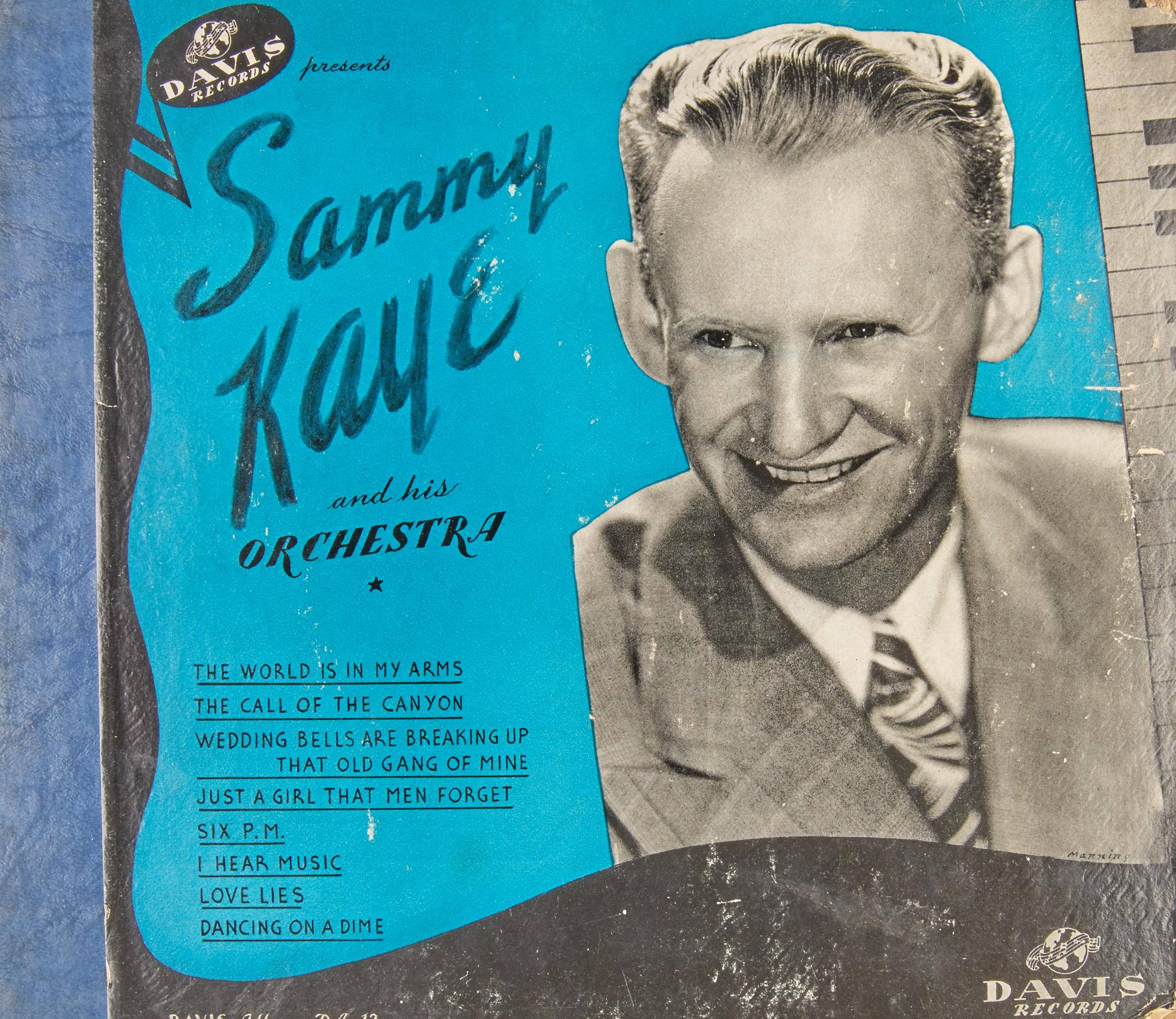 Album Cover 桌布 壁紙 — 復古Davis Records專輯封面，展示身穿西裝、面帶微笑的Sammy Kaye，背景為亮藍色，並附有歌曲名稱。