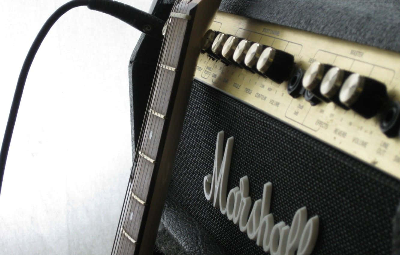 Guitar Amp 桌布 壁紙 — 復古Marshall吉他擴大機特寫，吉他琴頸靠在其上，顯示旋鈕和控制裝置。
