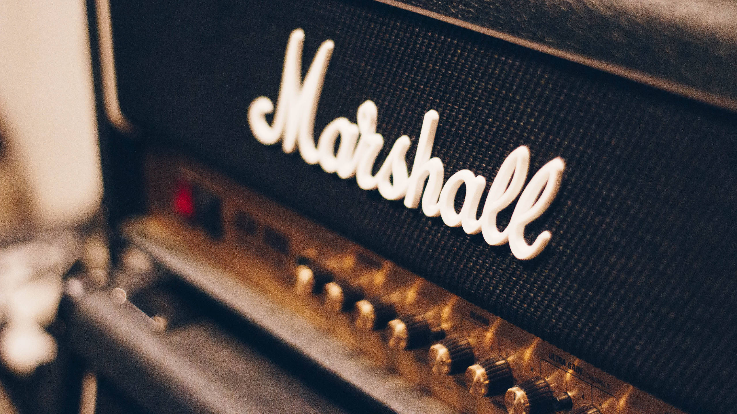 Marshall 桌布 壁紙 — 復古Marshall吉他音箱特寫，帶有發光旋鈕和溫暖燈光。