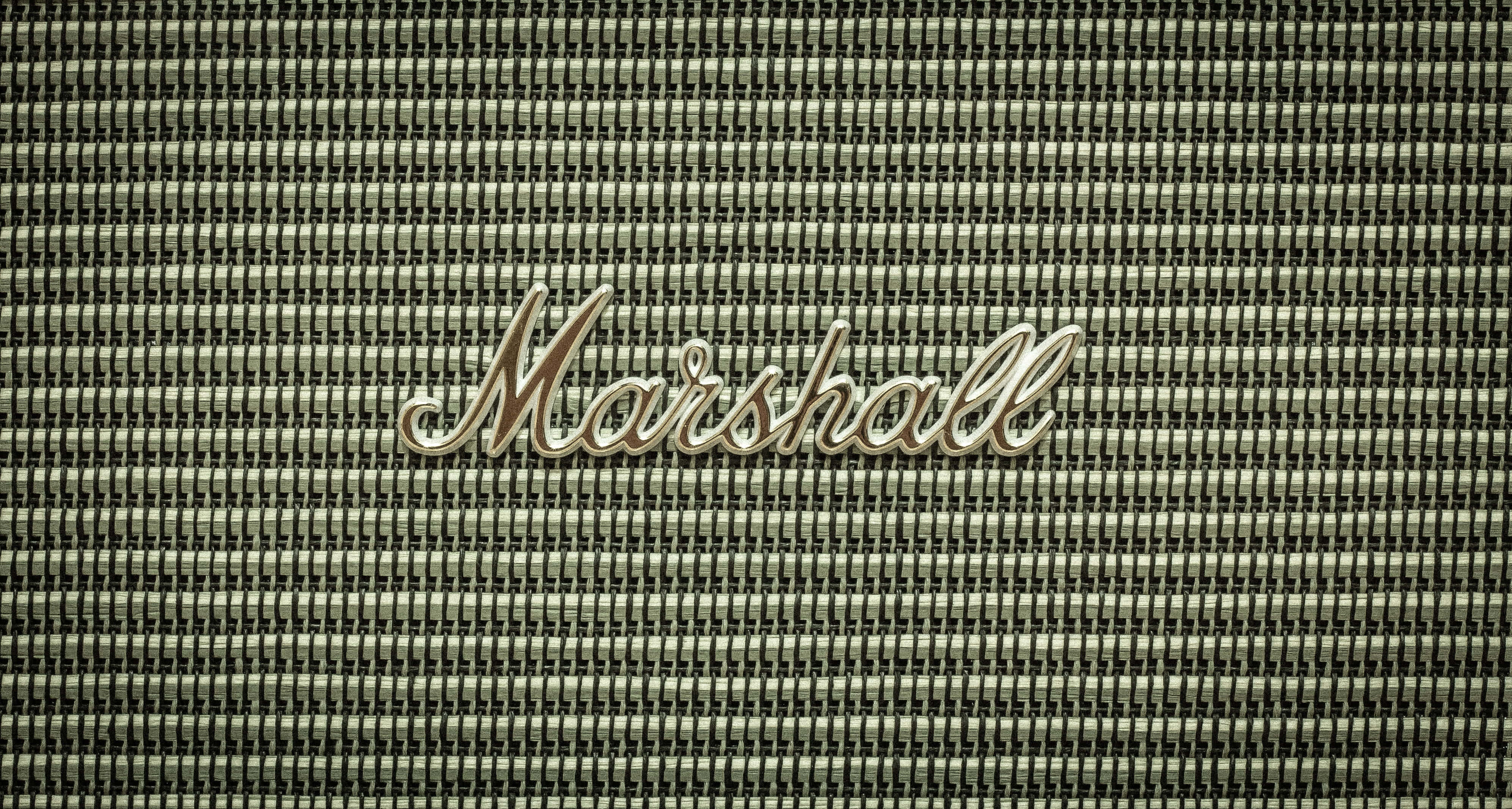Marshall 桌布 壁紙 — 復古Marshall擴音器格柵的特寫，帶有金屬標誌，背景為紋理織物。