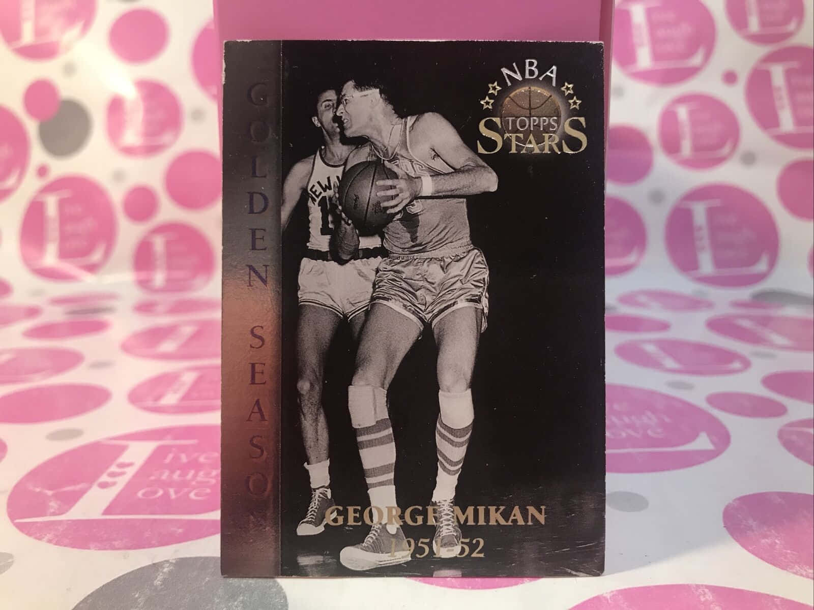 籃球 桌布 壁紙 — 復古NBA Topps Stars籃球卡， featuring George Mikan 在粉紅圓點背景上對抗防守球員的動作場面。