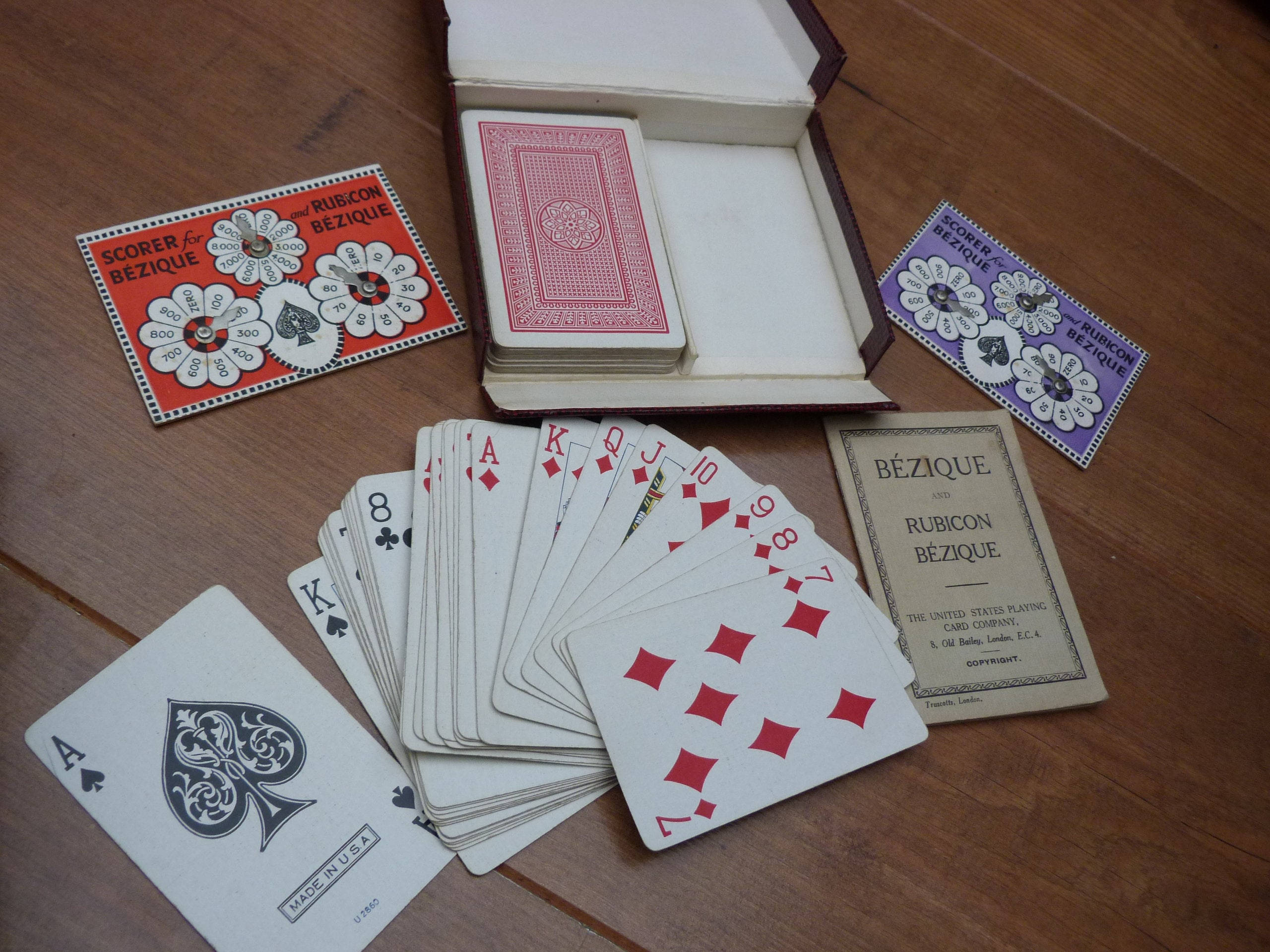 Playing Cards 桌布 壁紙 — 復古Rubicon Bezique撲克牌在木桌上扇形展開，附有計分卡和牌盒。