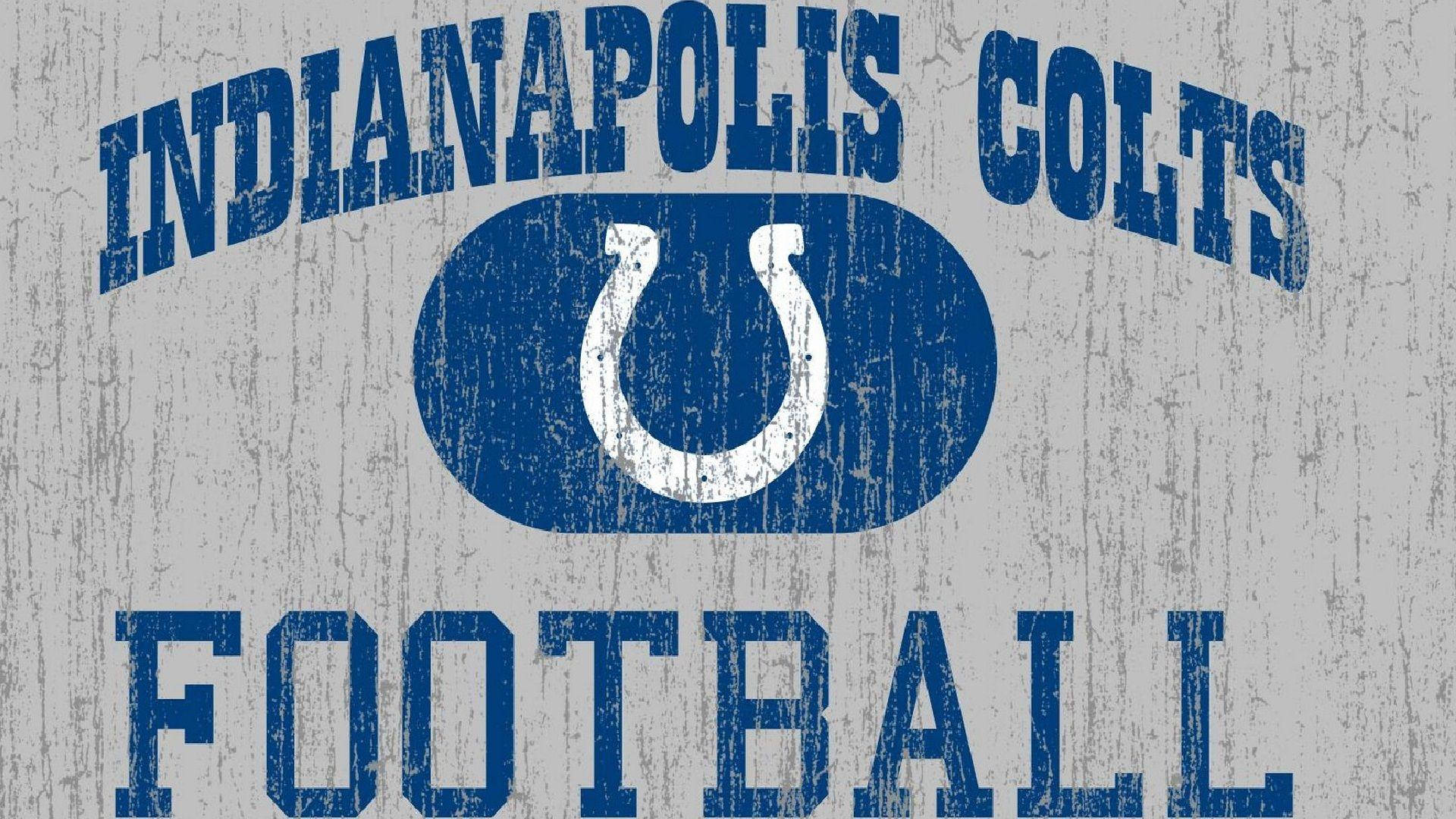 NFL 桌布 壁紙 — 復古印第安納波利斯小馬隊美式足球標誌，帶有磨損的藍色文字和馬蹄鐵，位於風化的灰色木紋上。
