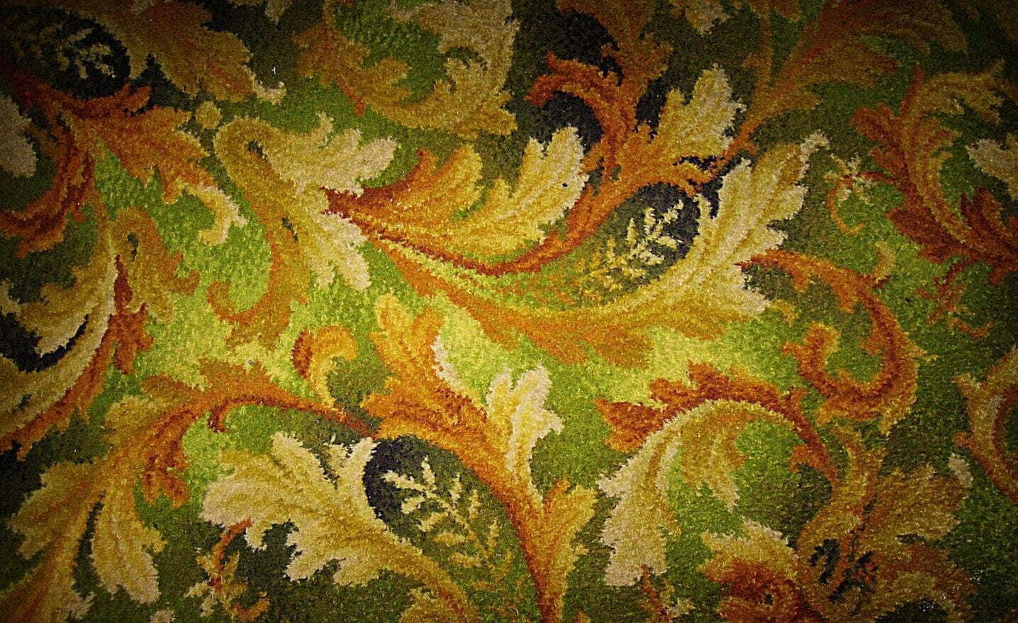 Carpet 桌布 壁紙 — 復古地毯近照，帶有綠色、金色和黑色調的漩渦葉片圖案。