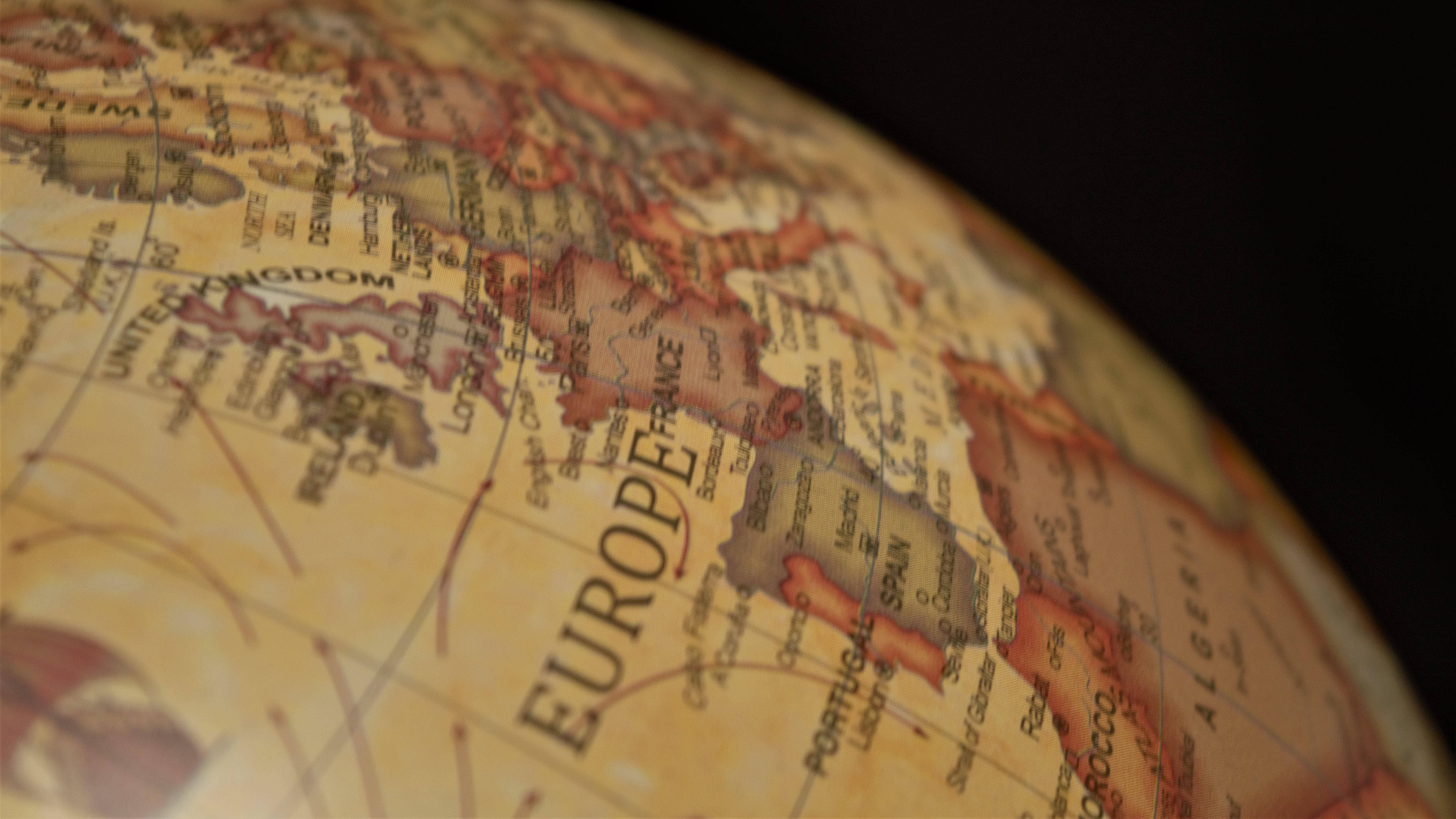 World Globe 桌布 壁紙 — 復古地球儀特寫，以溫暖色調凸顯歐洲，並對周圍大陸進行柔焦處理。
