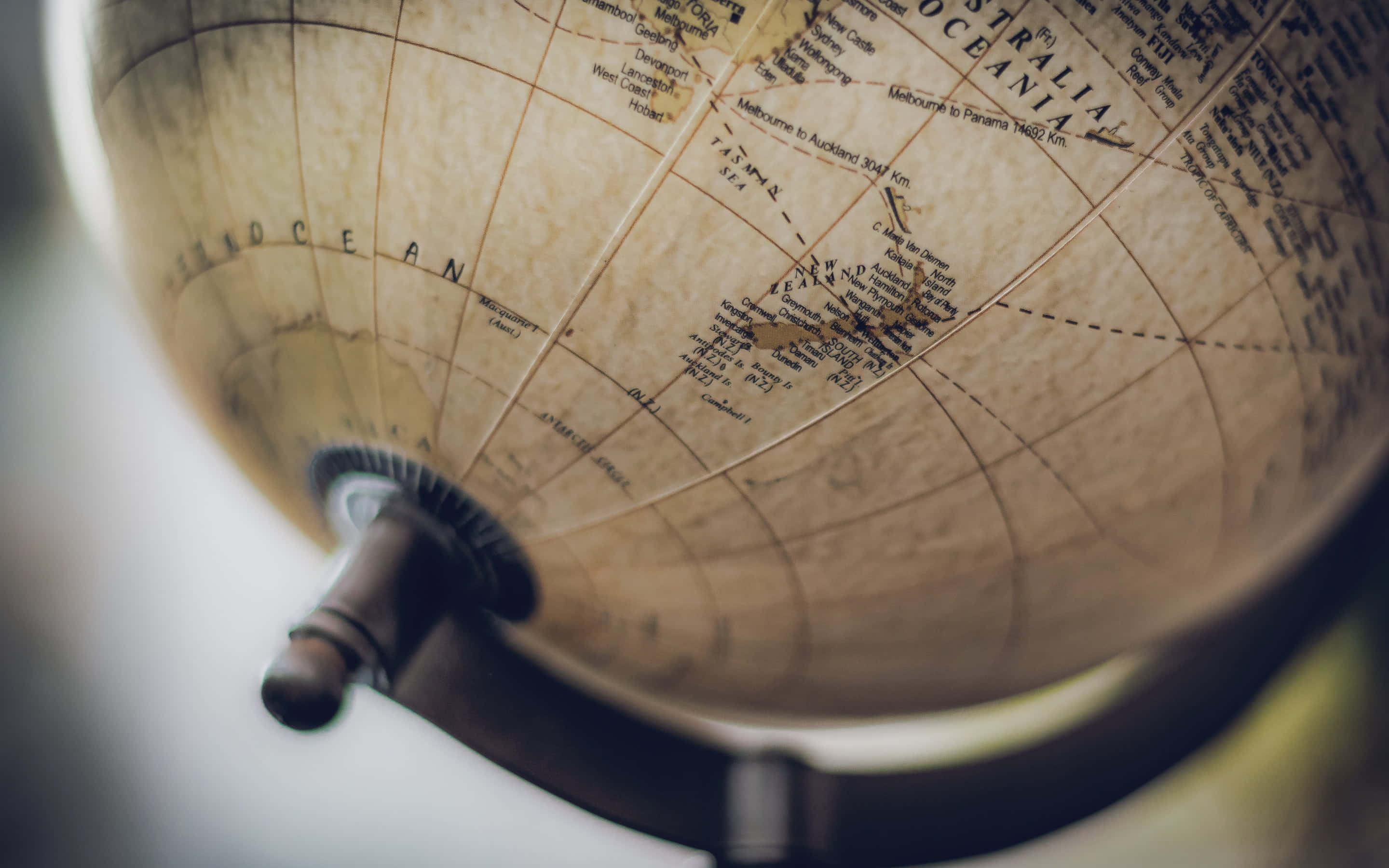 World 桌布 壁紙 — 復古地球儀特寫，顯示澳洲及周圍海洋，帶有柔和溫暖的燈光。