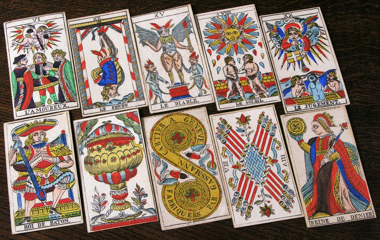 Tarot Card 桌布 壁紙 — 復古塔羅牌，帶有華麗插圖和法語文字，排列在深色木質表面上。