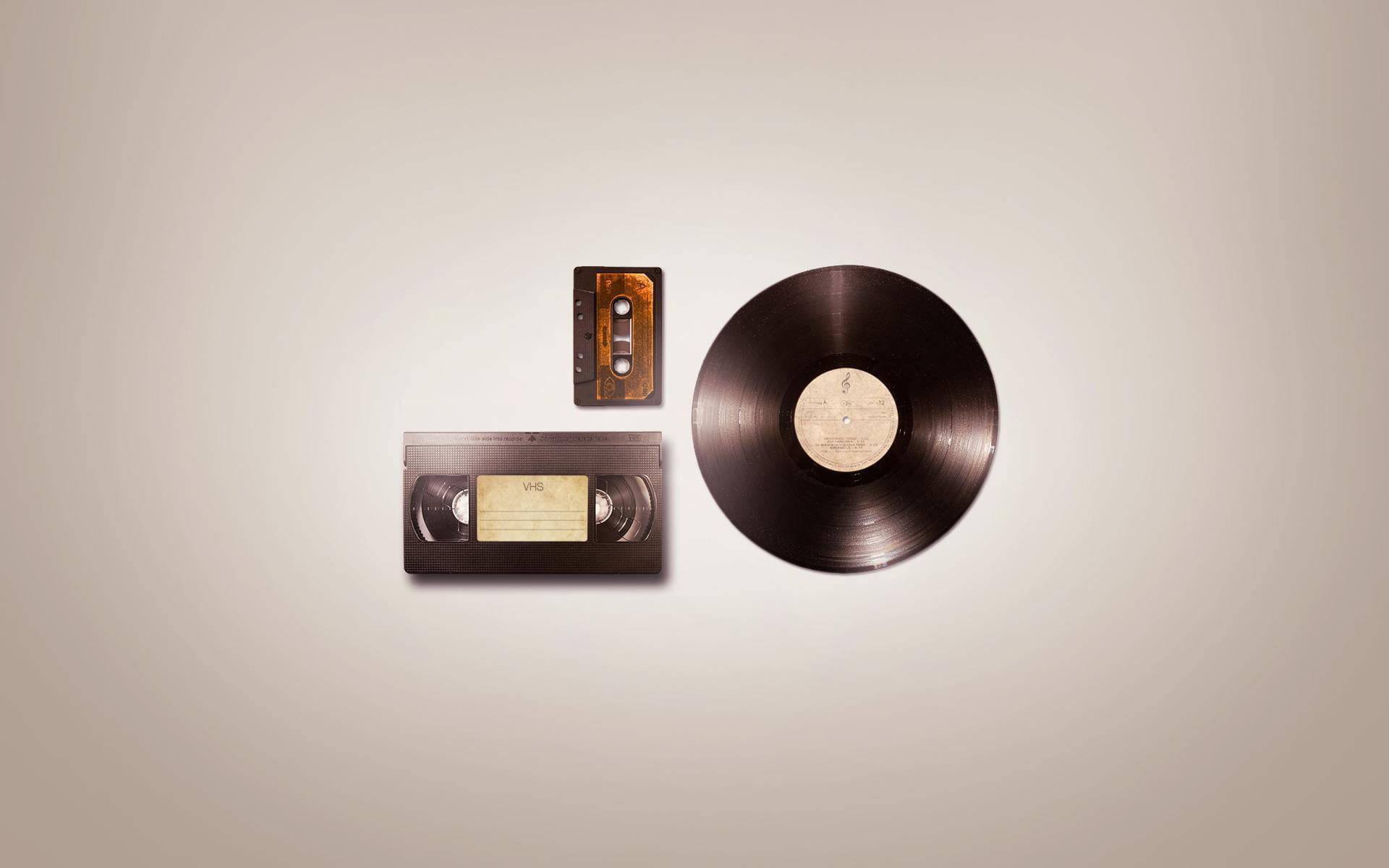 Retro Aesthetic 桌布 壁紙 — 復古媒體物品，包括VHS錄影帶盒和黑膠唱片，排列在中性米色背景上。