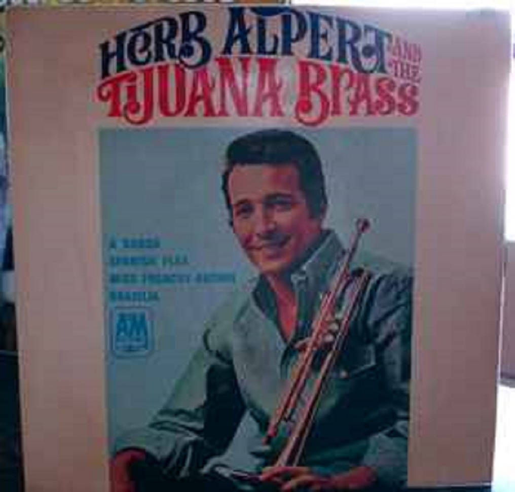 band 桌布 壁紙 — 復古專輯封面，Herb Alpert 微笑著手持小號，背景為淺藍色。