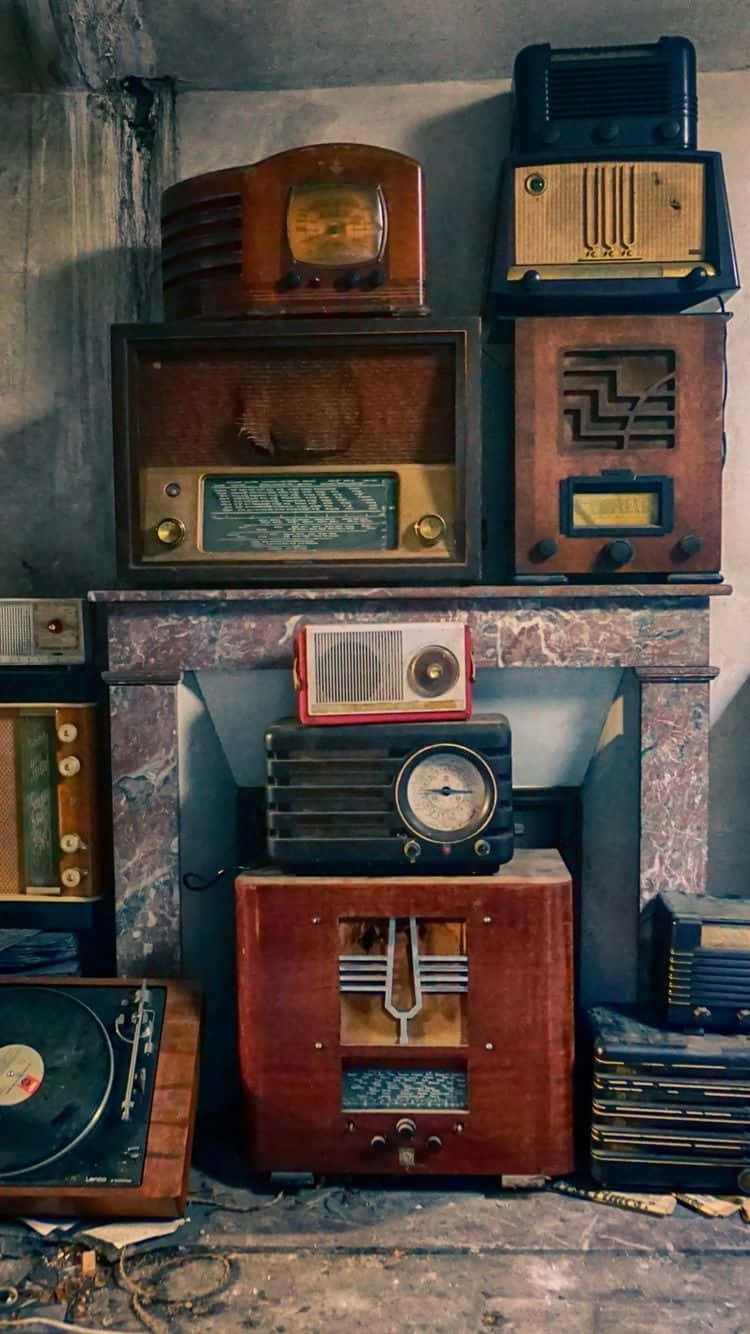 復古 桌布 壁紙 — 復古收音機和留聲機堆疊在大理石壁爐架上，房間昏暗佈滿灰塵。