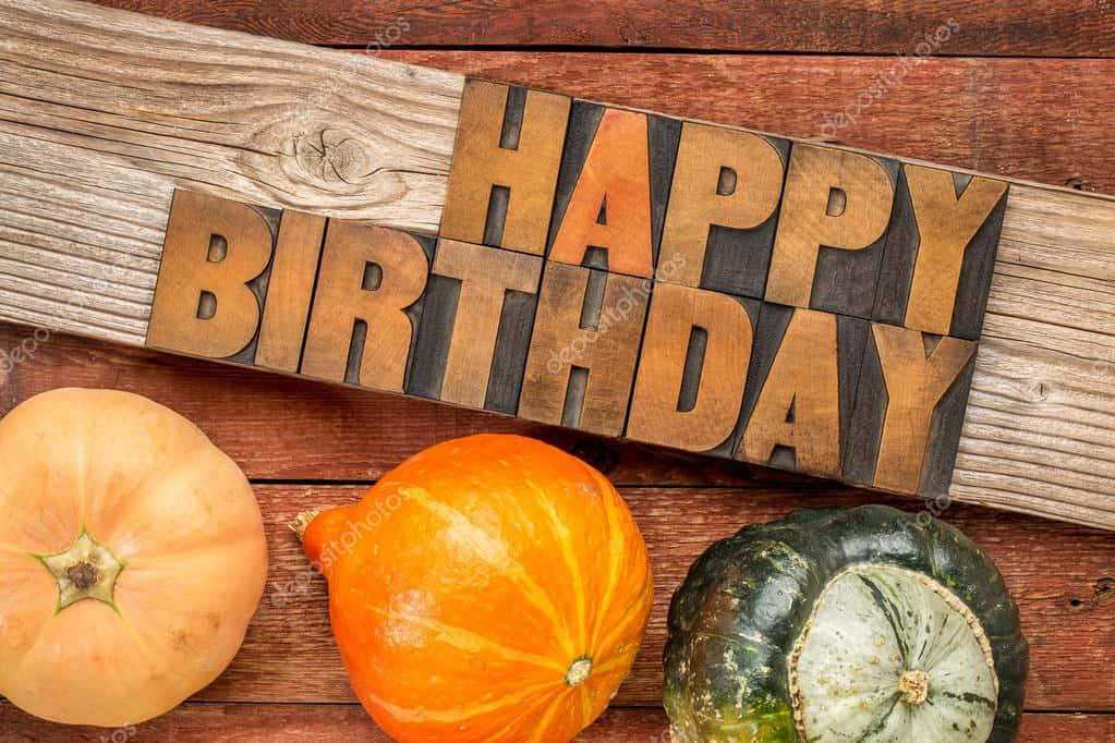 秋季 桌布 壁紙 — 復古木活字印刷機在質樸的木頭上拼出 happy birthday，旁邊有秋季南瓜。