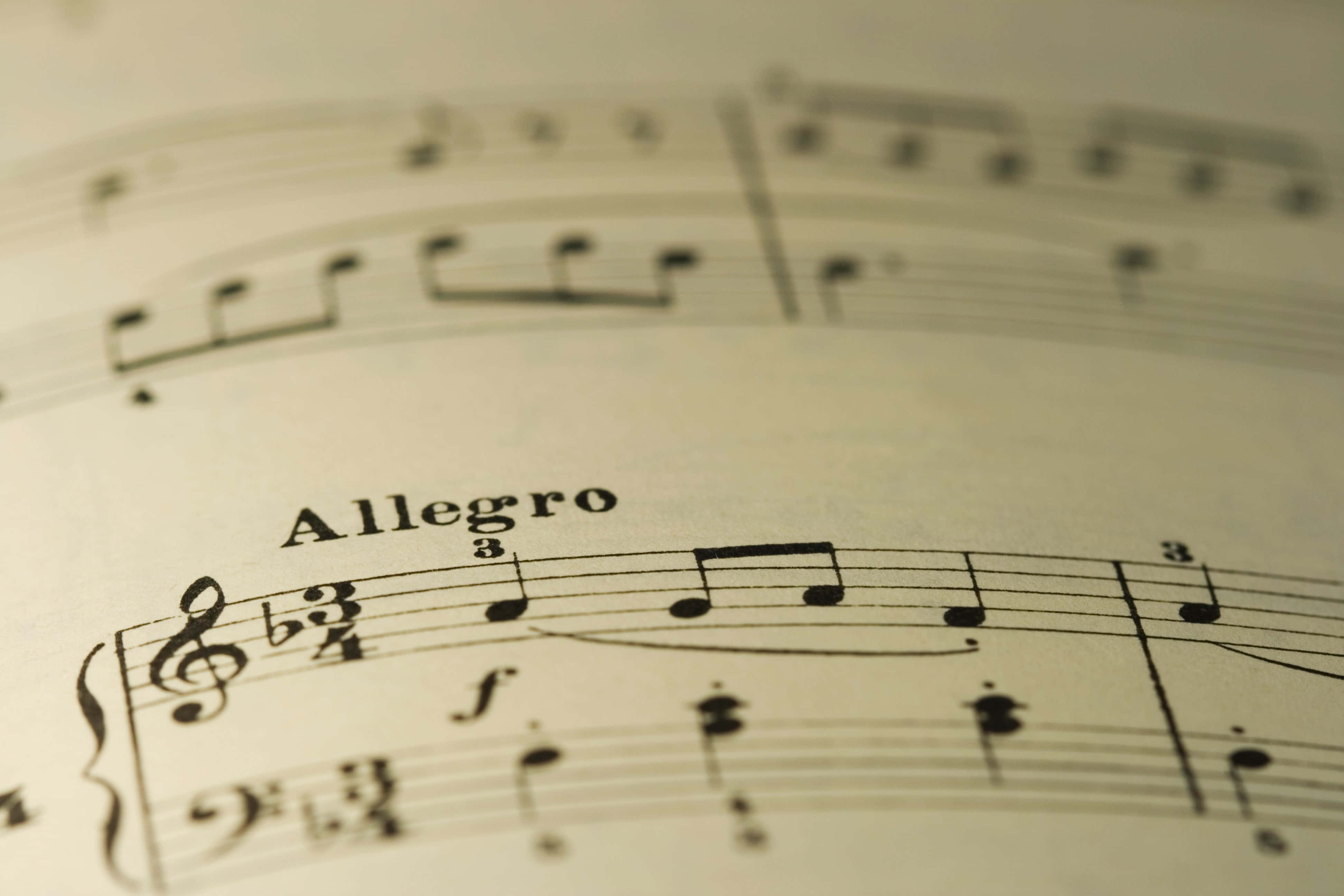 音樂 桌布 壁紙 — 復古樂譜特寫，帶有「Allegro」速度標記和音符，紙張已泛黃。