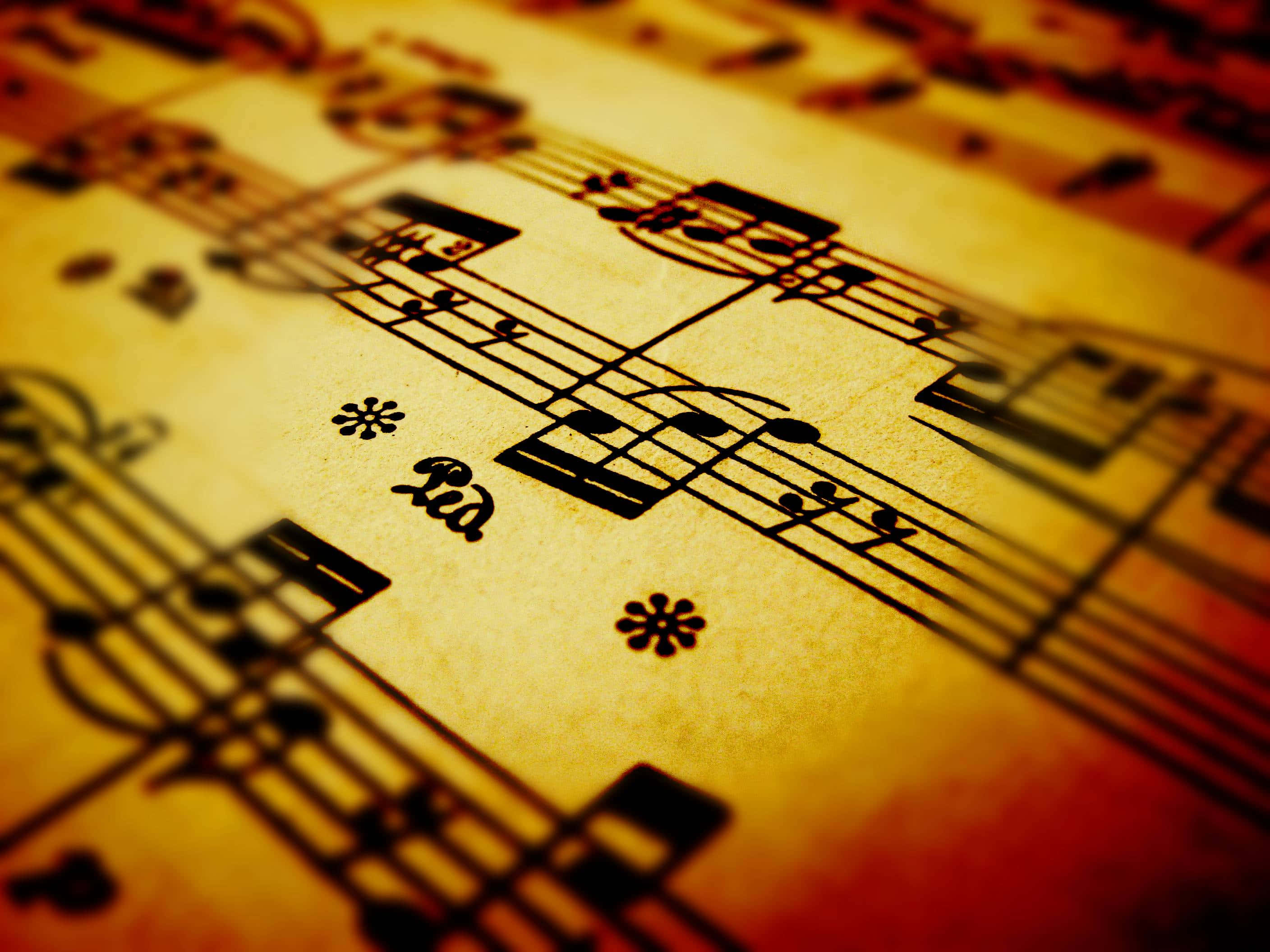 Classical Music 桌布 壁紙 — 復古樂譜的特寫，帶有溫暖的金色色調，並柔和對焦於音符和五線譜上。