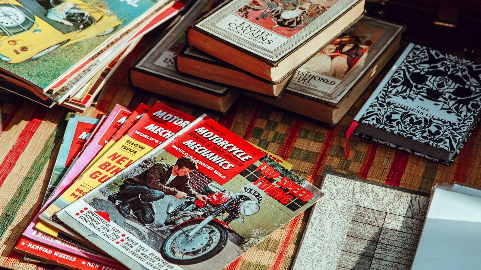 Aesthetic Retro 桌布 壁紙 — 復古機車雜誌和經典書籍放在一張條紋木桌上，沐浴在溫暖的陽光中。