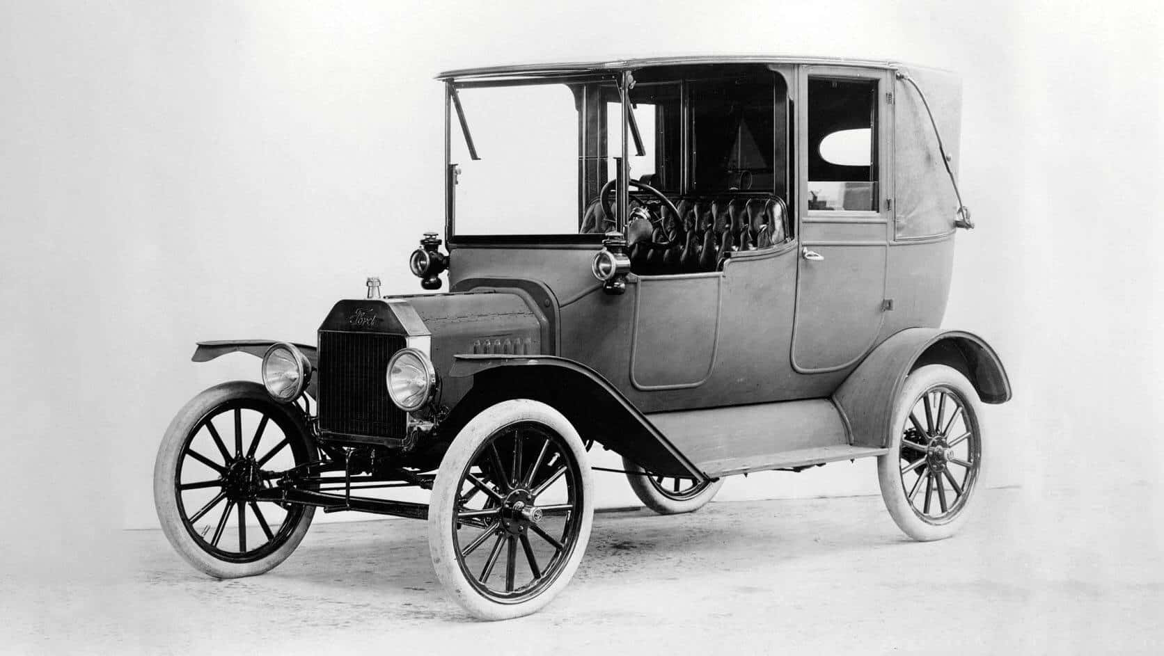 Ford Logo 桌布 壁紙 — 復古福特Model T汽車，配備鋼絲輪轂和帆布車頂，在純色工作室背景前擺拍。