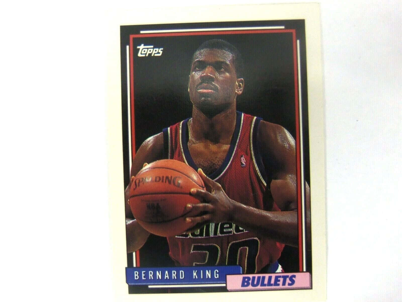 Athletic 桌布 壁紙 — 復古籃球卡， featuring Bernard King 身穿紅色子彈隊球衣，手持 Spalding 籃球，背景為黑色。