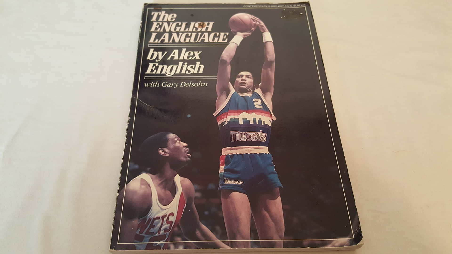 復古籃球書封面，Alex English在防守球員上方投籃。 — NBA 壁紙