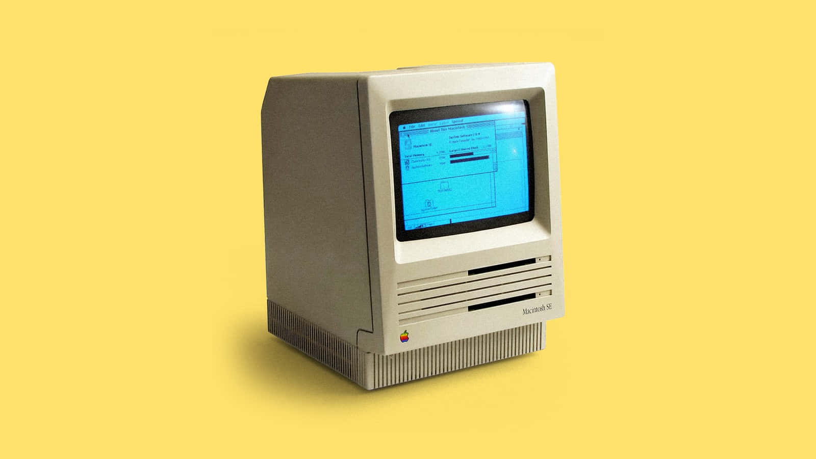 machines 桌布 壁紙 — 復古米色 Macintosh SE 電腦，藍色螢幕，居中放置在純黃色背景上。
