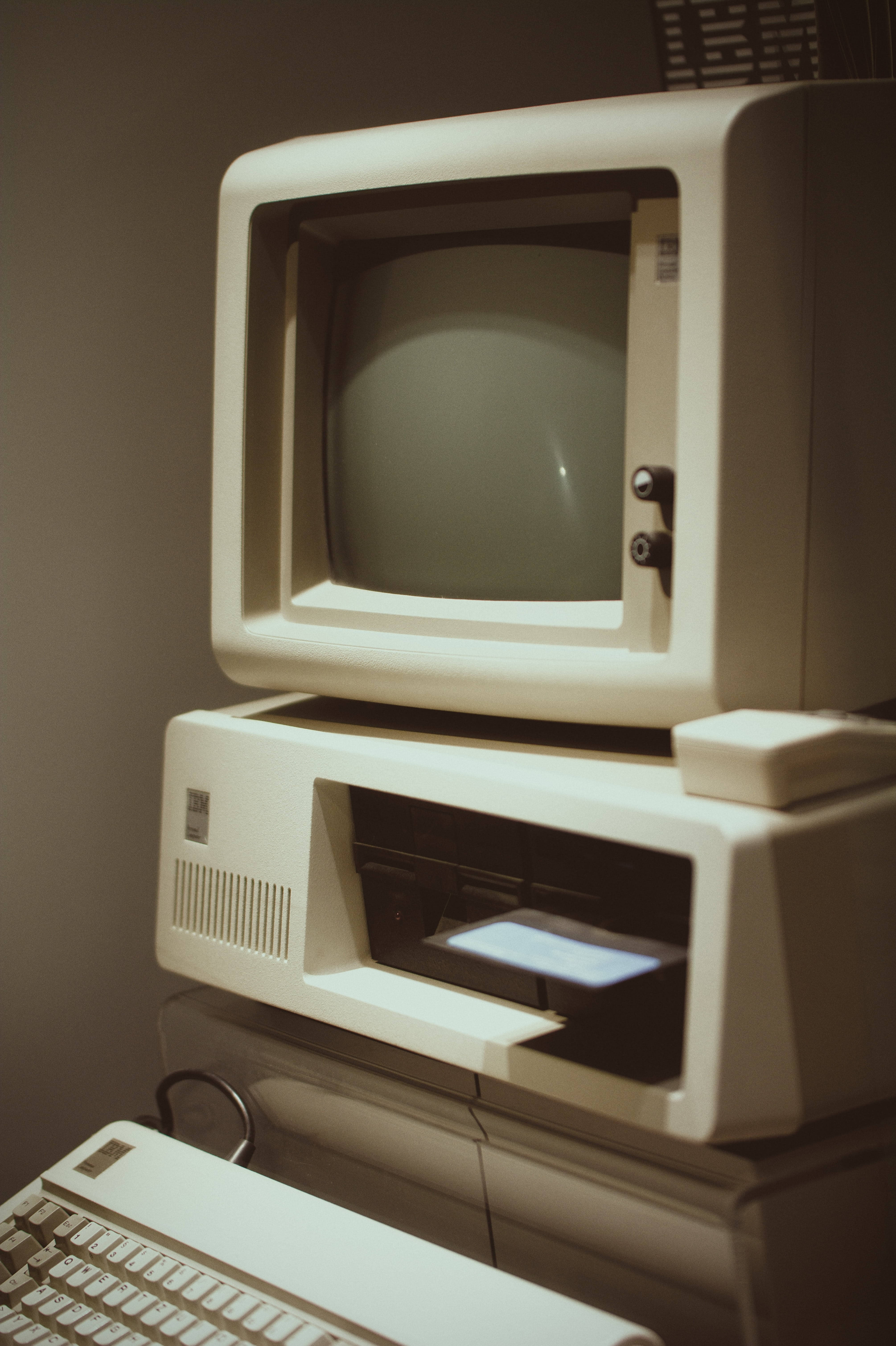 Retro Aesthetic 桌布 壁紙 — 復古米色電腦設置，配備CRT顯示器、鍵盤和印表機，沐浴在溫暖懷舊的光線中。